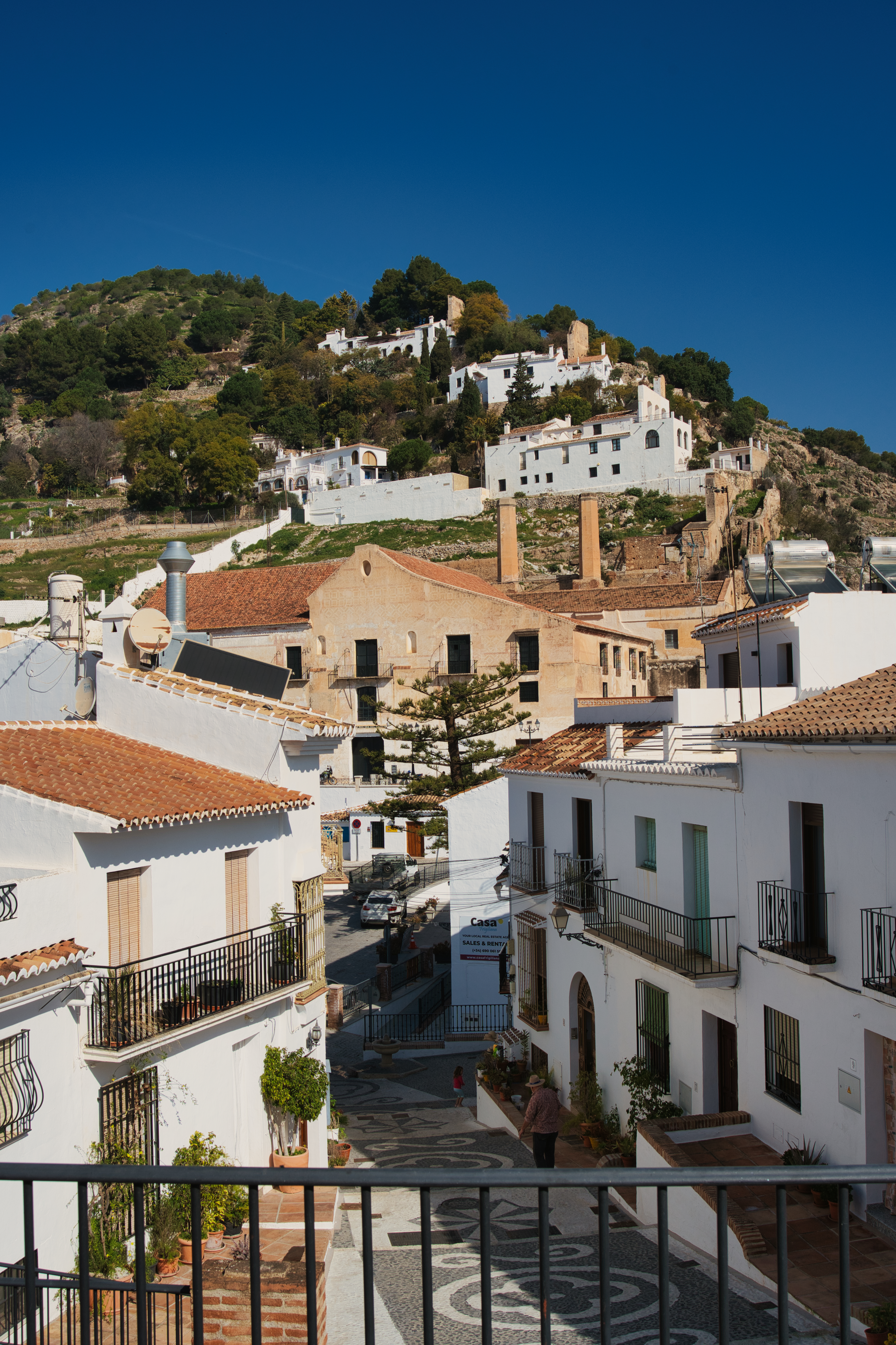 Rooftop view over Frigiliana's white houses toward the El Fuerte hillside