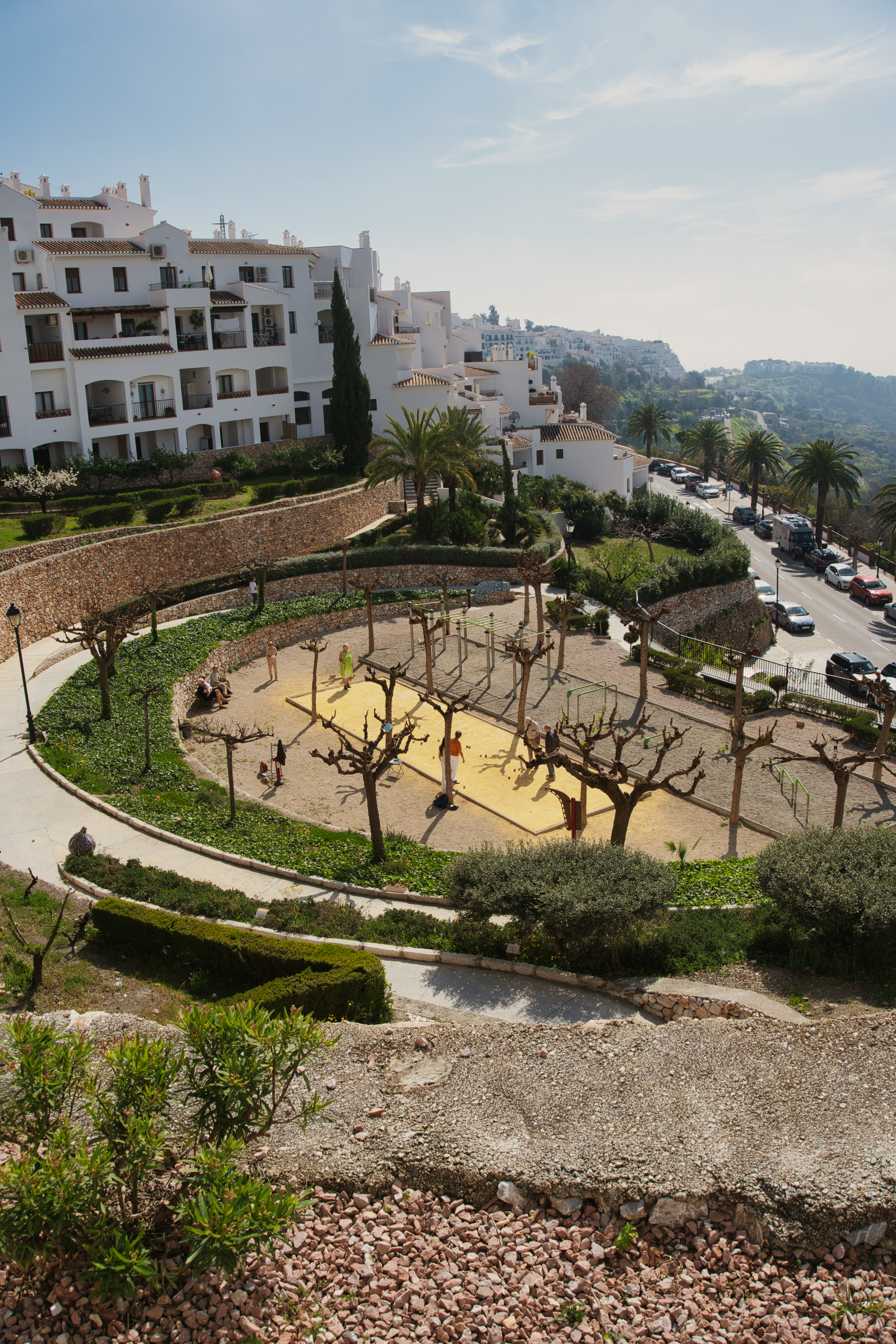 The circular outdoor gym at Molineta park in Frigiliana, with the village behind