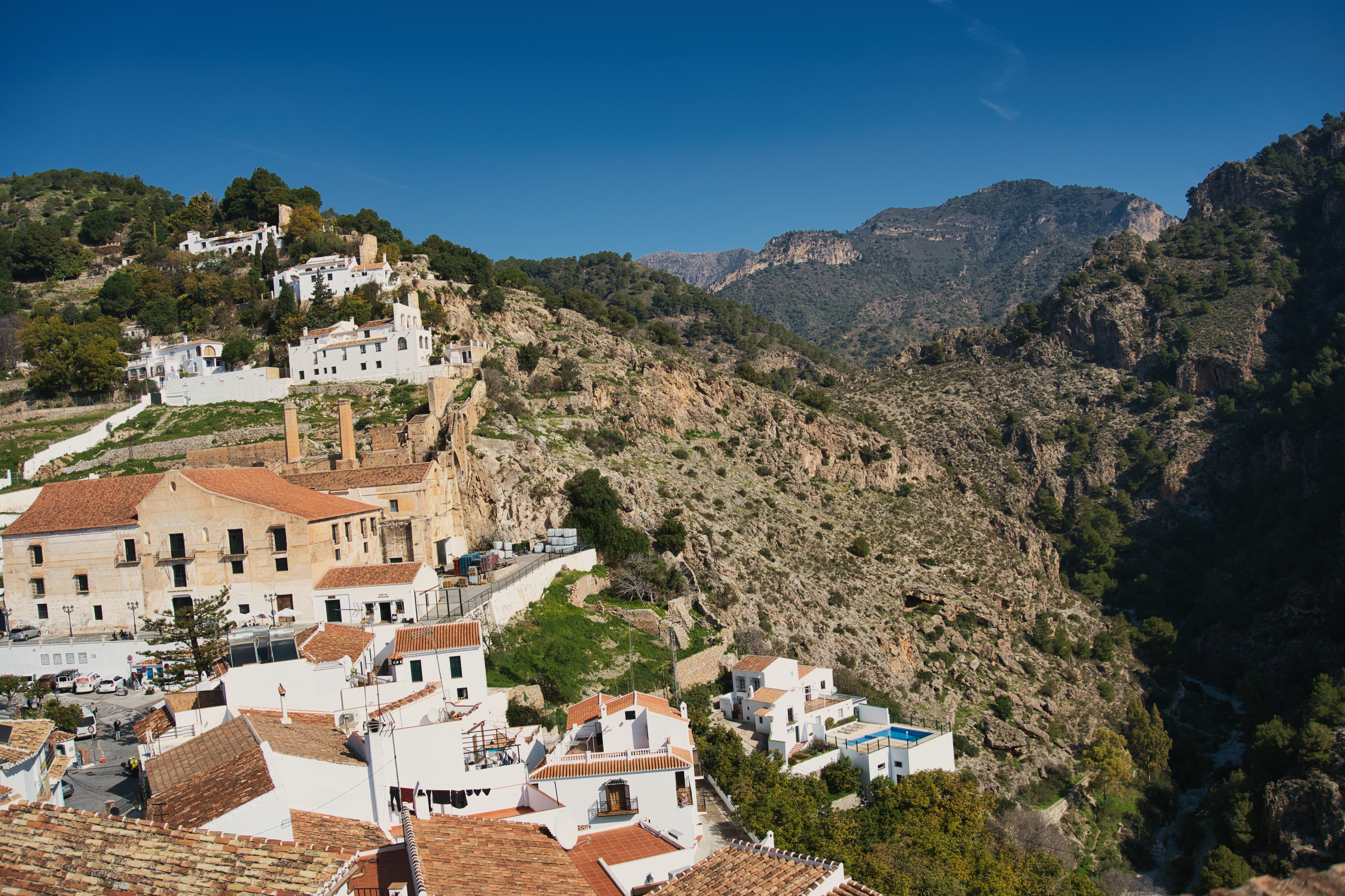 Wide view over Frigiliana's hillside rooftops with the sierra behind