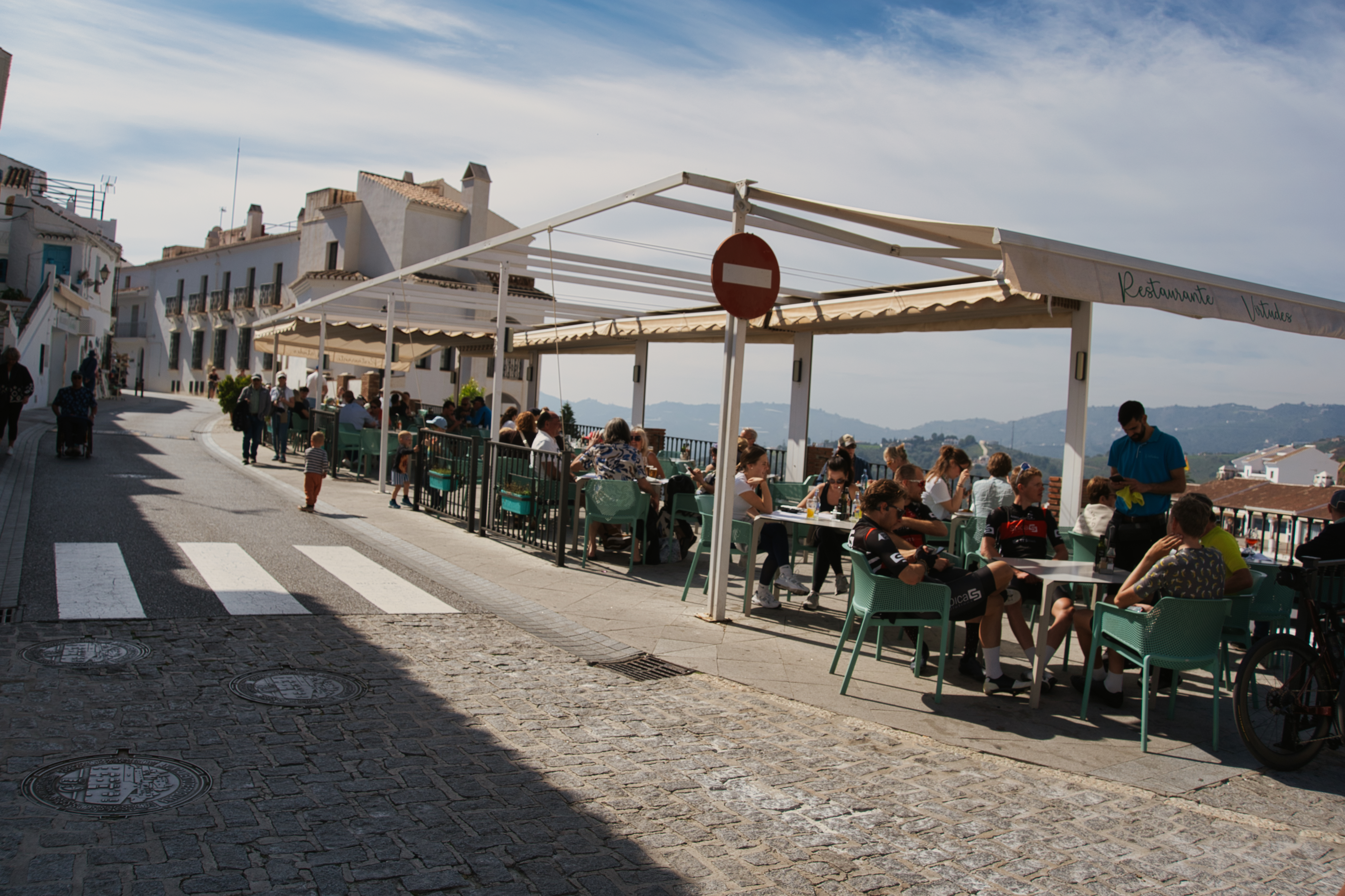Diners on the terrace of Restaurante Virtudes in Frigiliana, with valley views behind