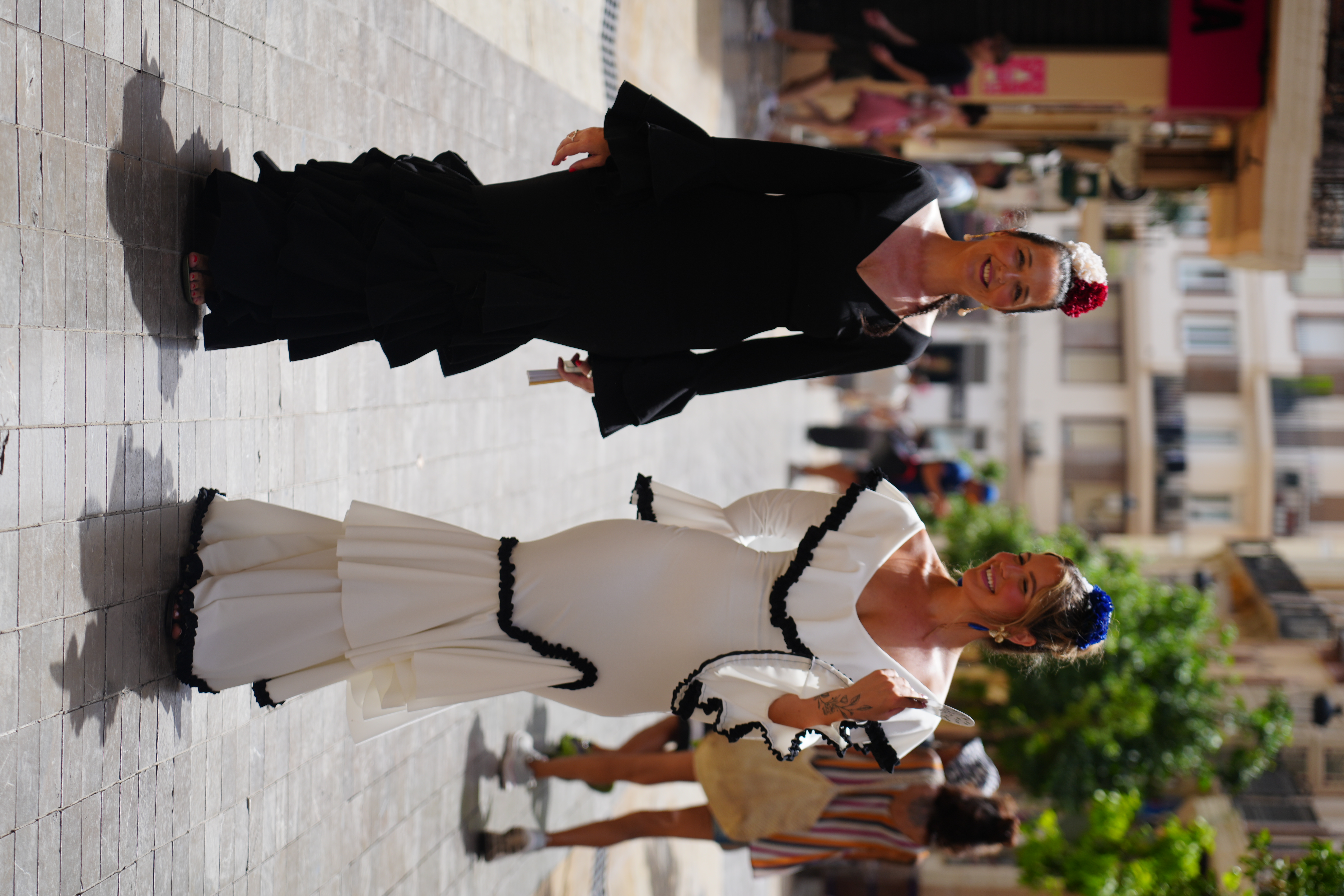 Two women in flamenco feria dresses at Malaga's spring fair
