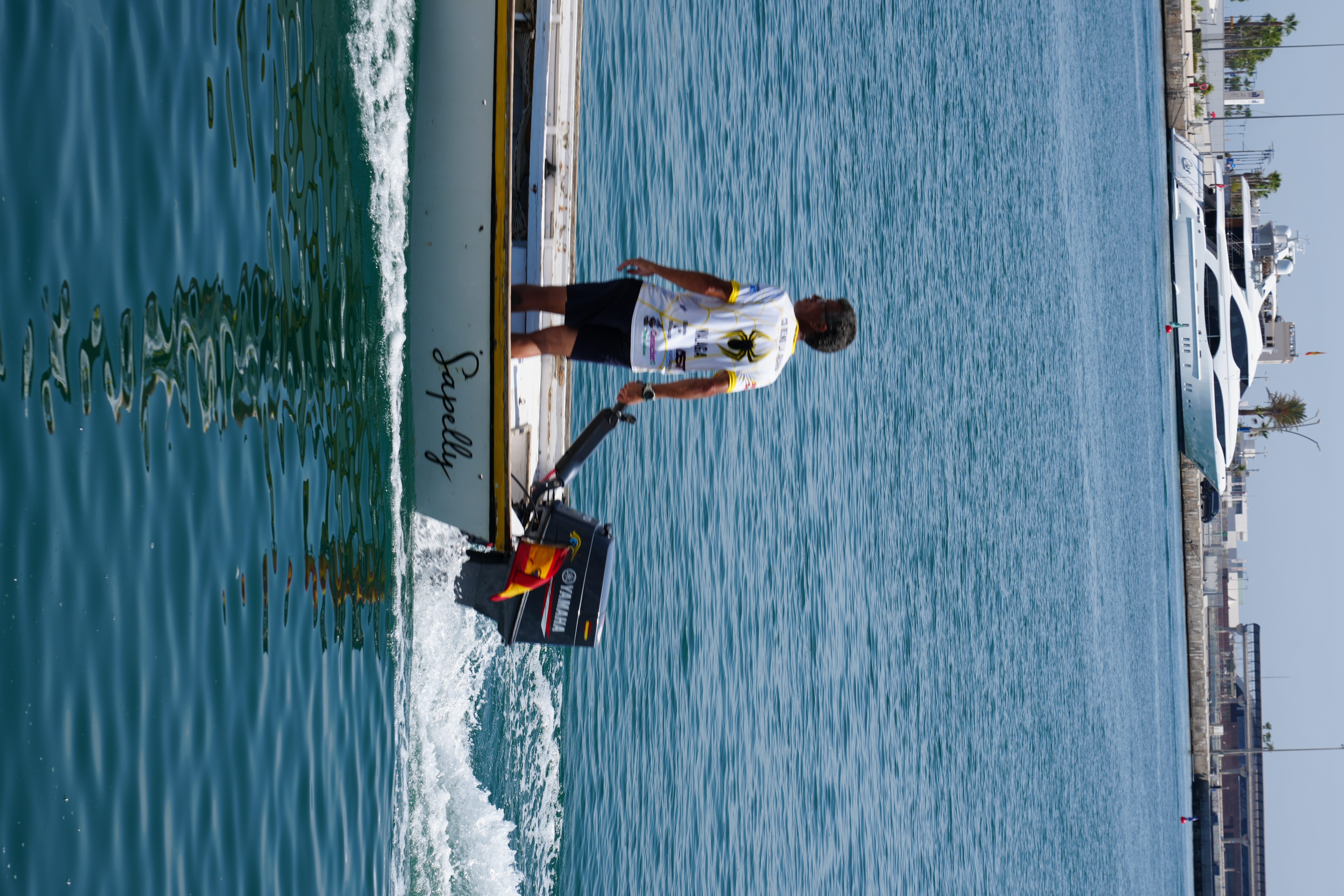 A support motorboat following a jabega rowing race off Malaga's coast