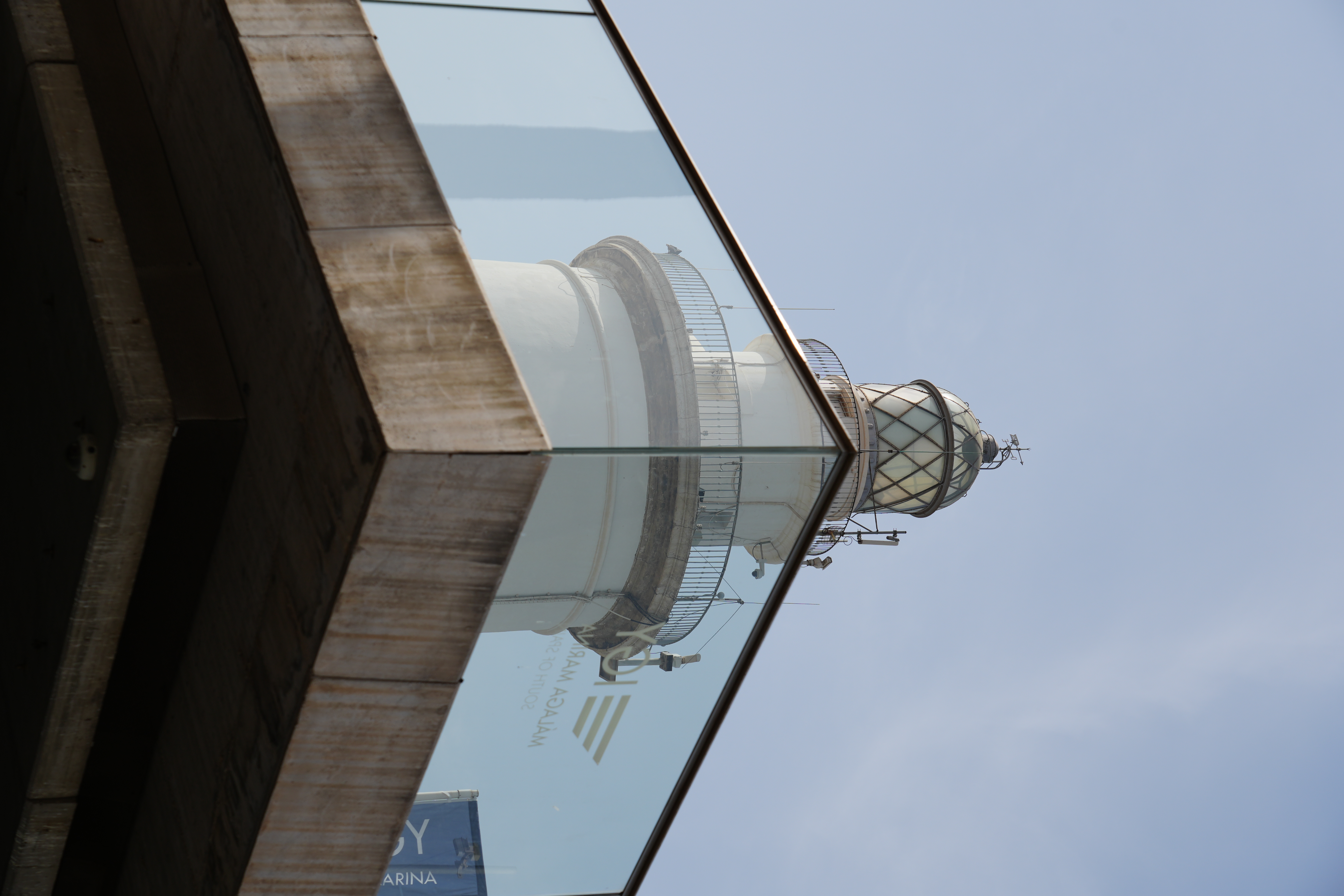 Close-up of La Farola lighthouse in Malaga, reflected in glass