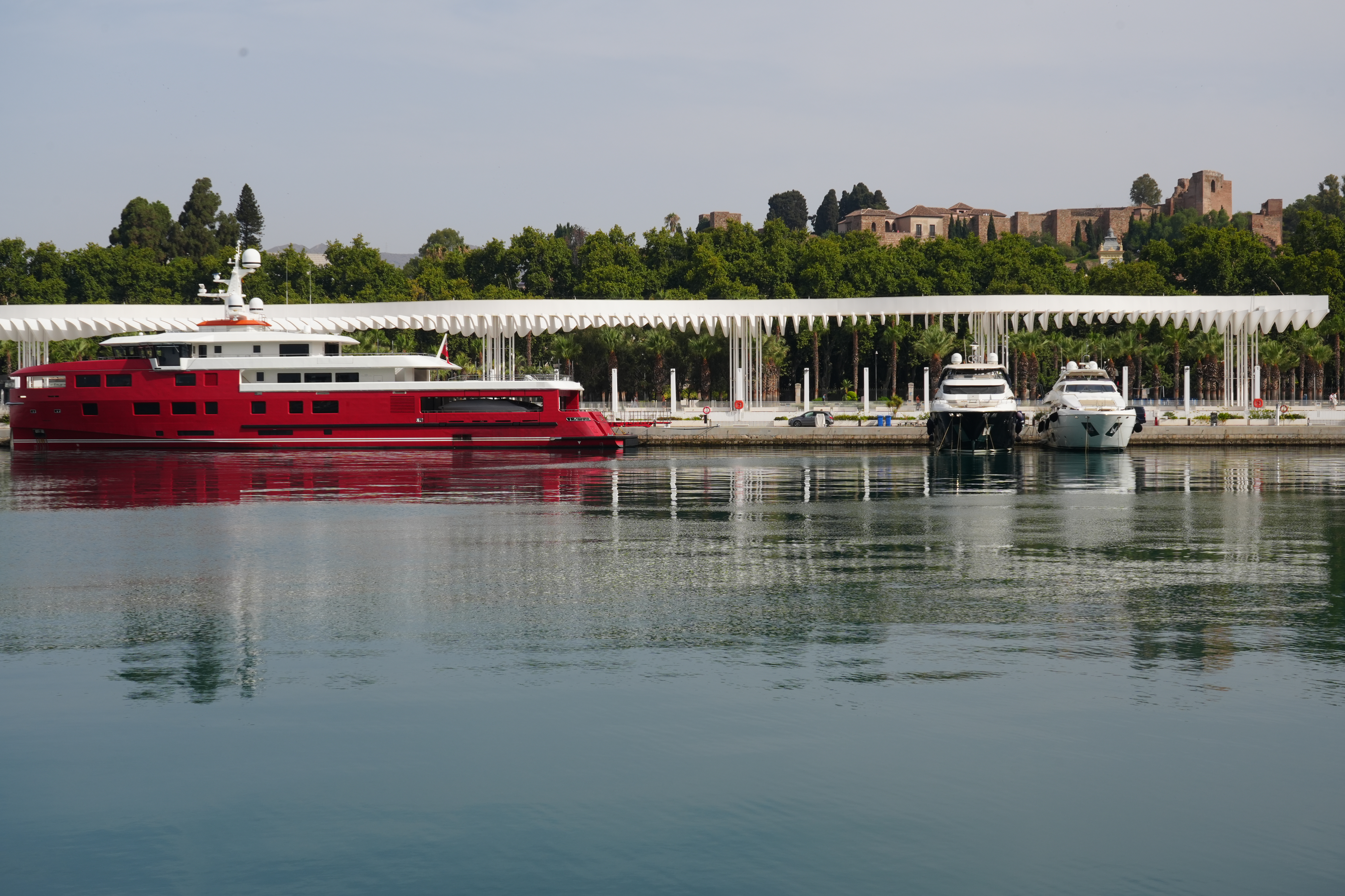 Yachts moored in Malaga's marina with the Alcazaba fortress behind