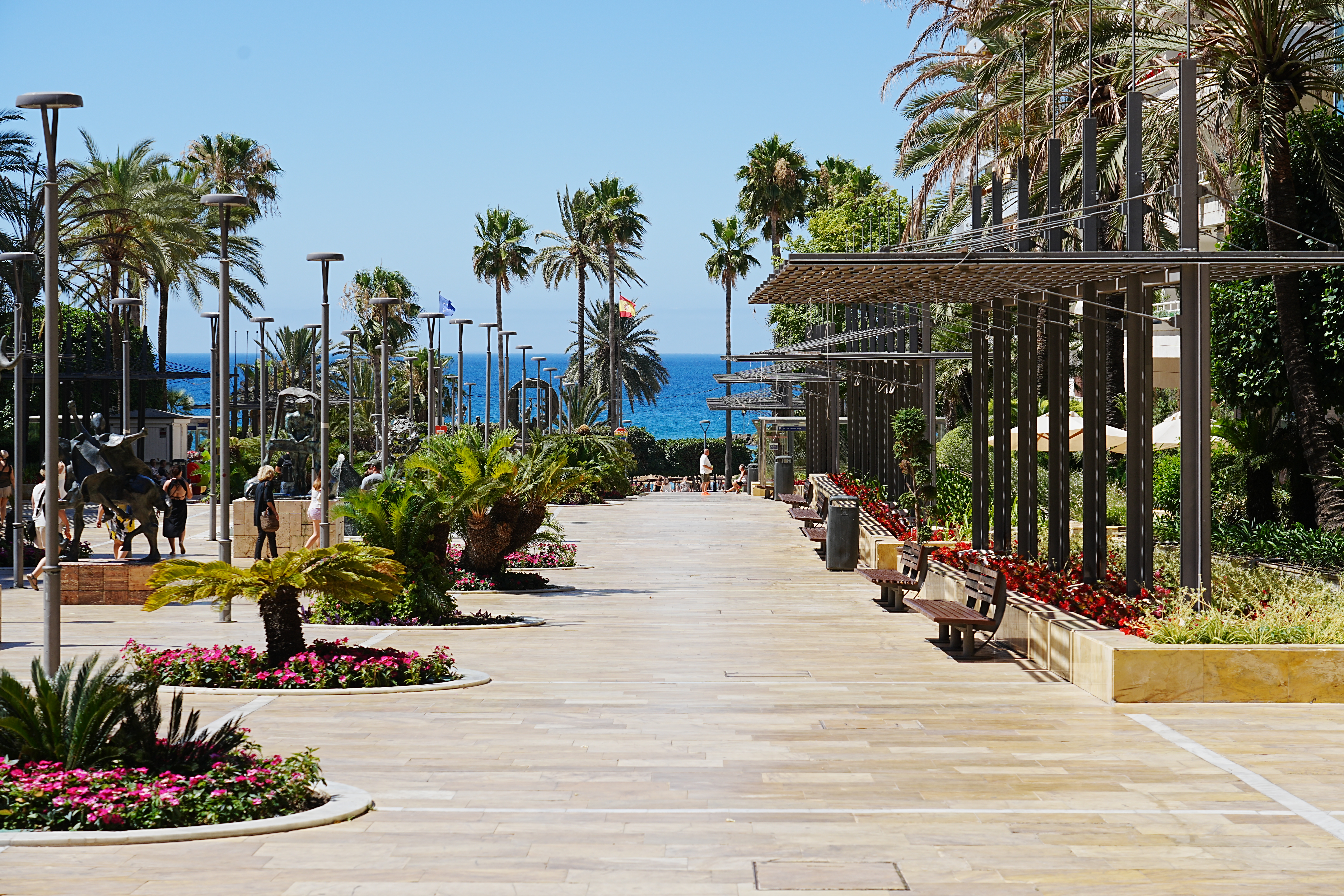 Avenida del Mar promenade in Marbella, lined with sculptures and palms, leading to the sea