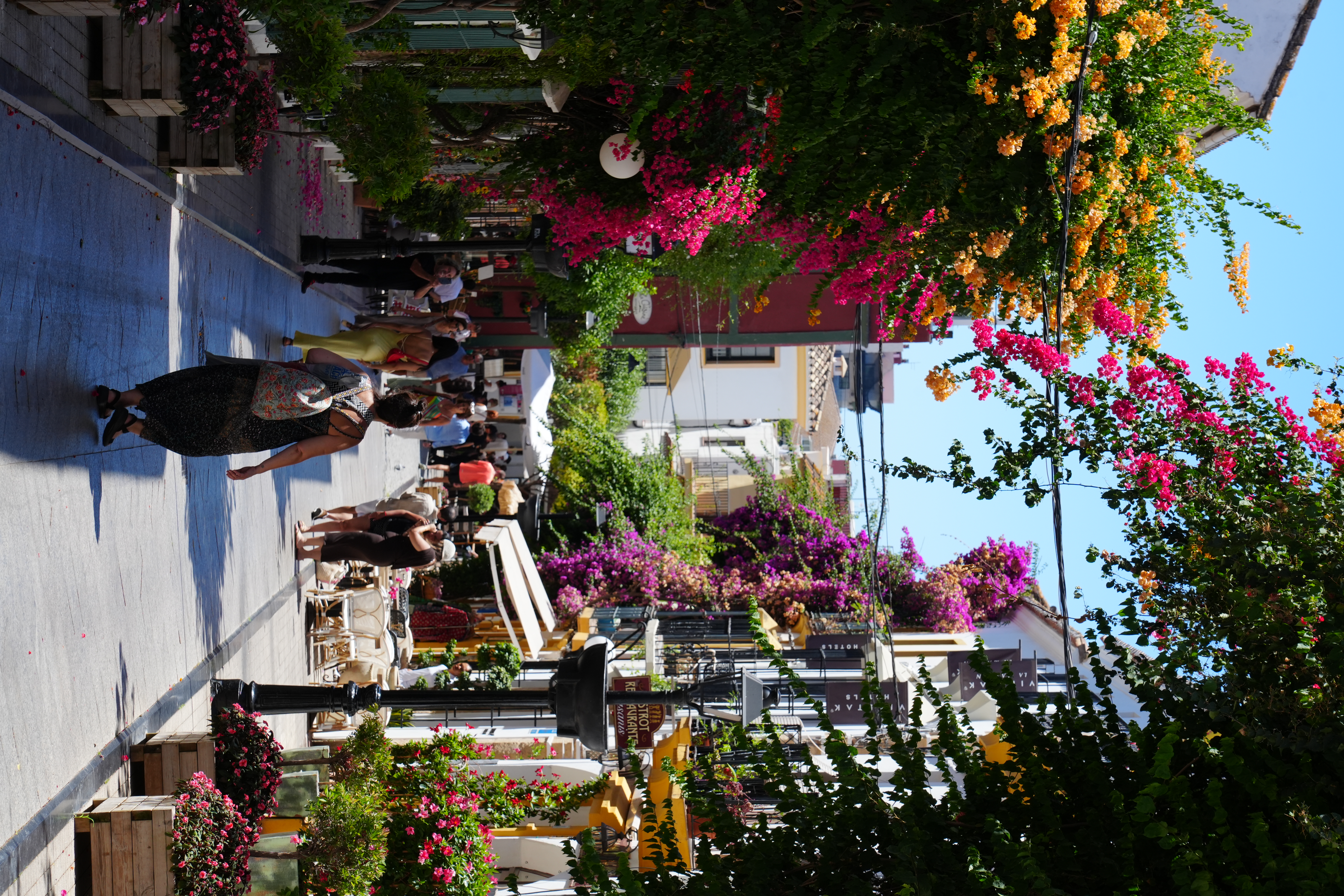 A bougainvillea-covered street in Marbella's Old Town lined with restaurants
