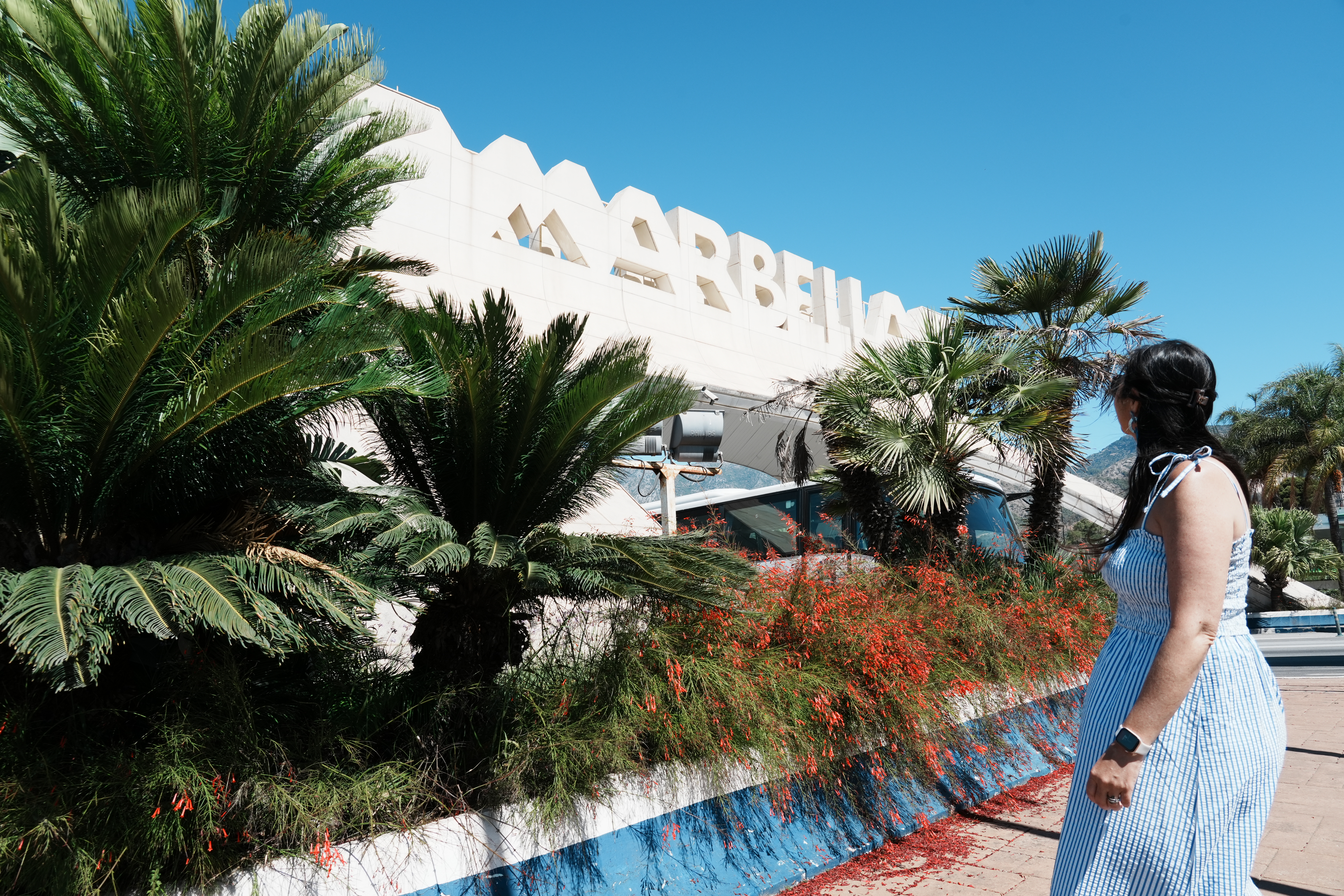 The Marbella city sign on the congress centre wall, framed by palms