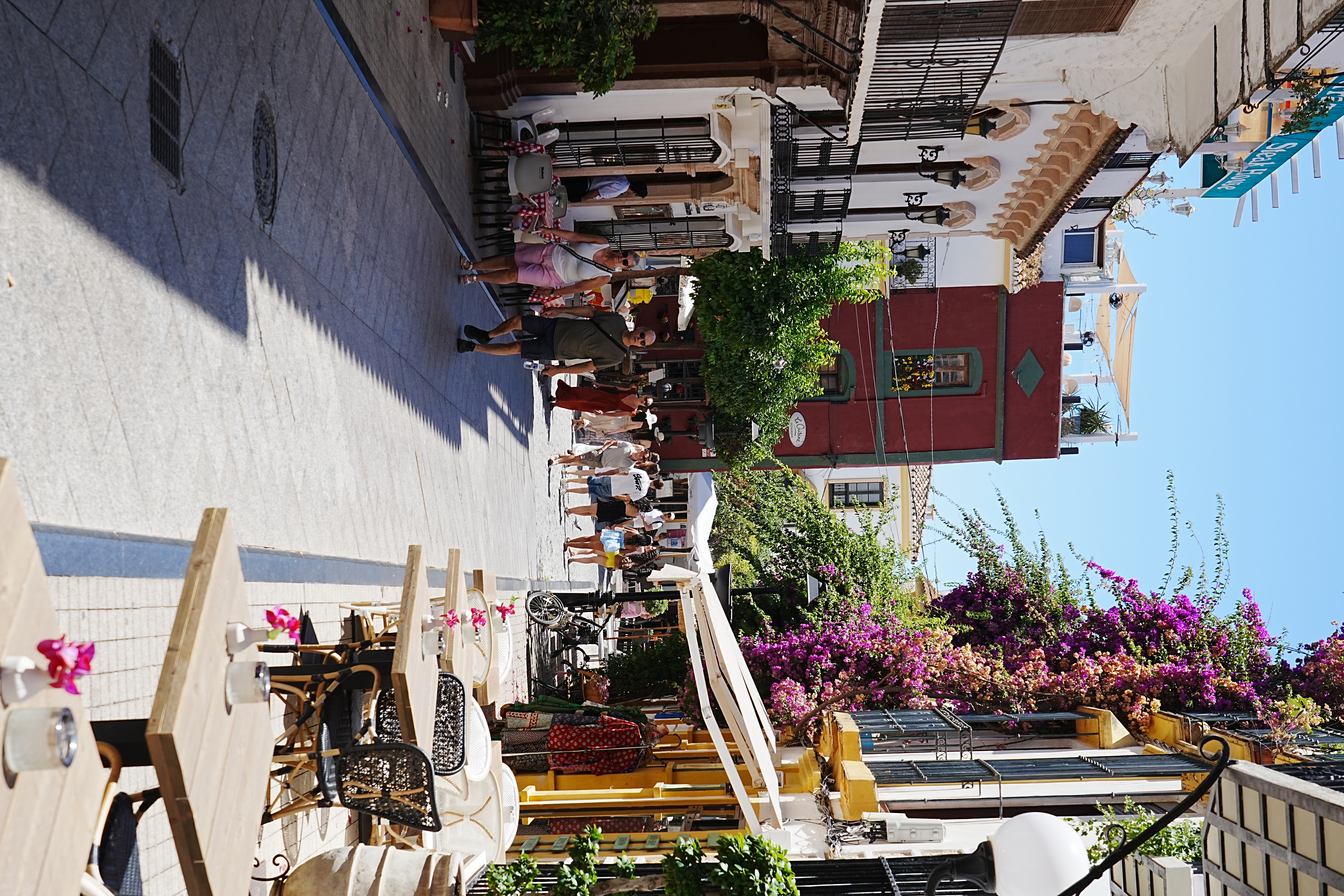 A lively street in Marbella's Old Town with restaurants and bougainvillea