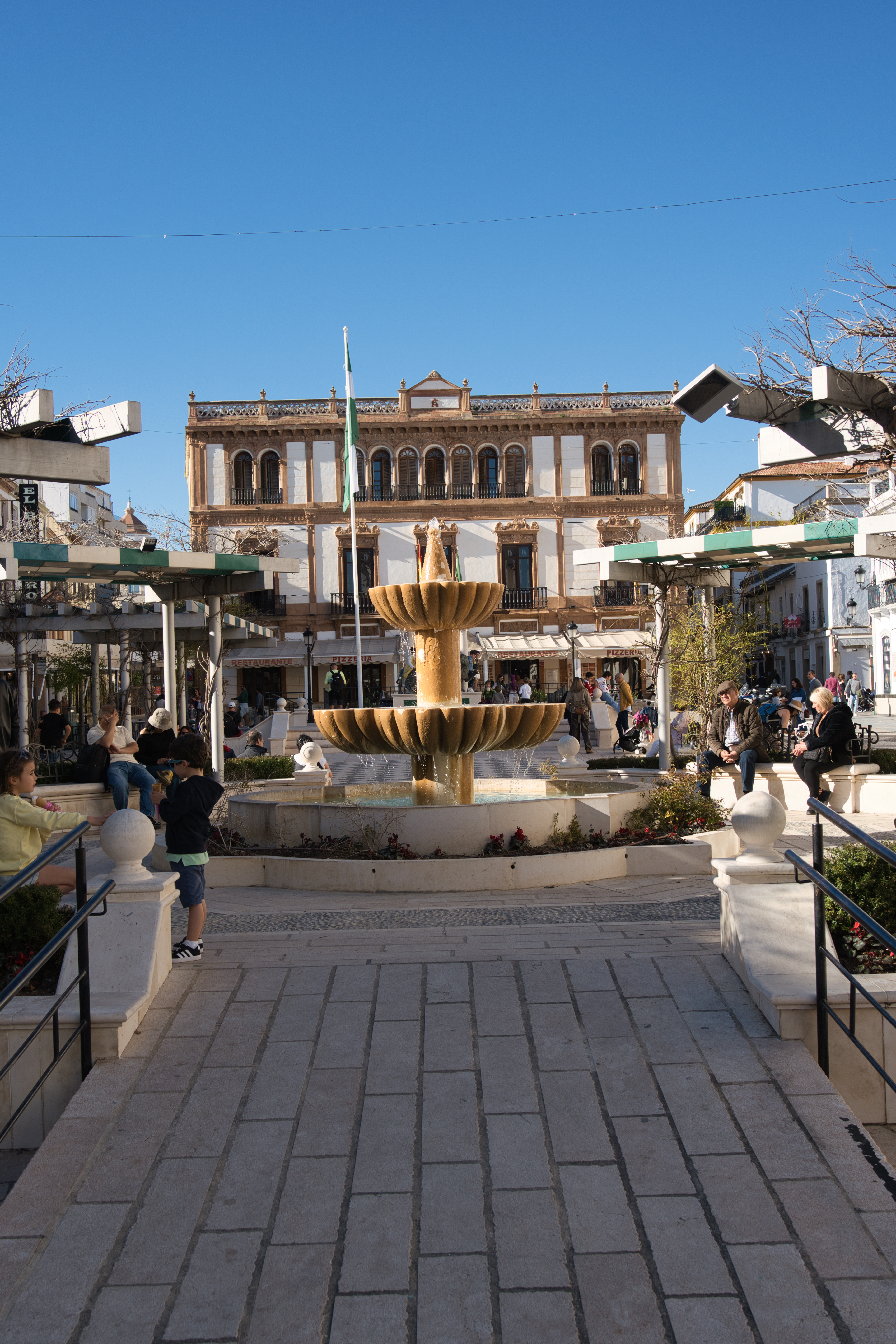 The fountain in Plaza del Socorro, Ronda, with the ornate building behind