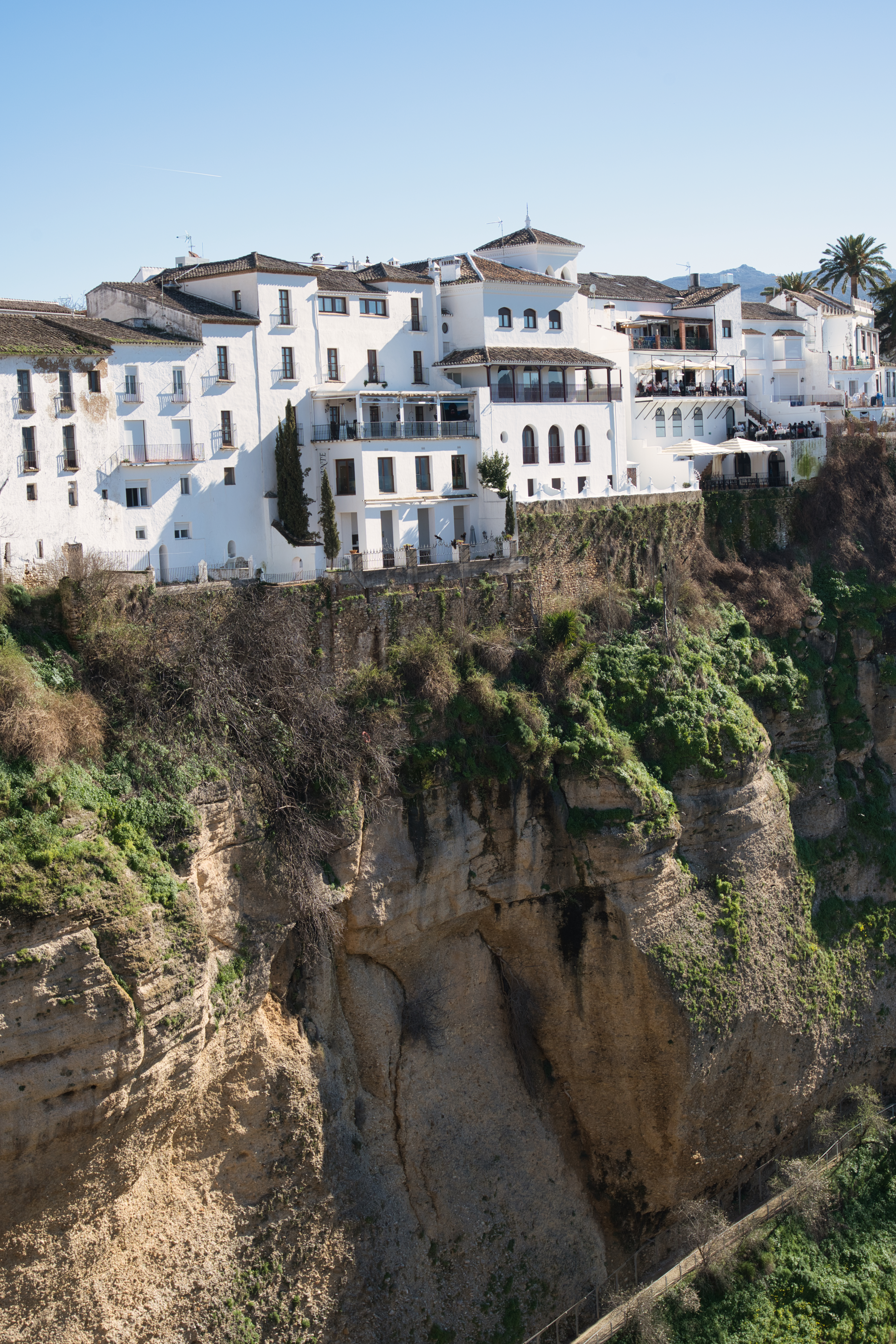 White houses perched on the cliff edge above El Tajo gorge in Ronda