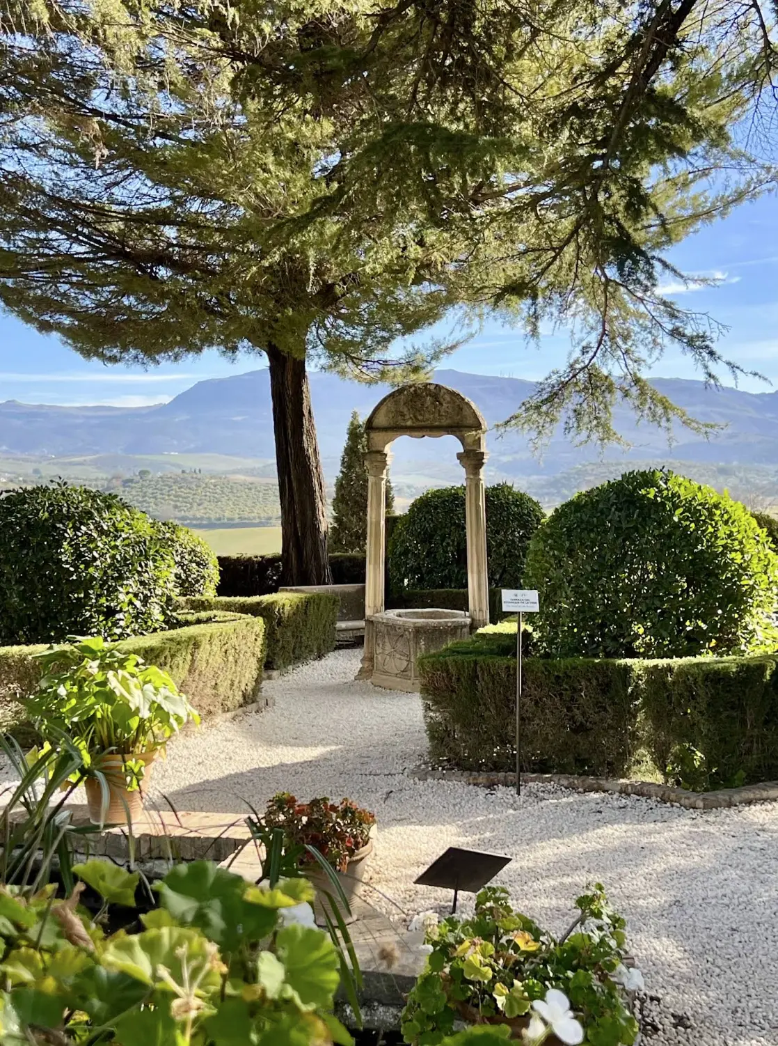 Formal garden with stone arch and mountain views at the Casa del Rey Moro in Ronda