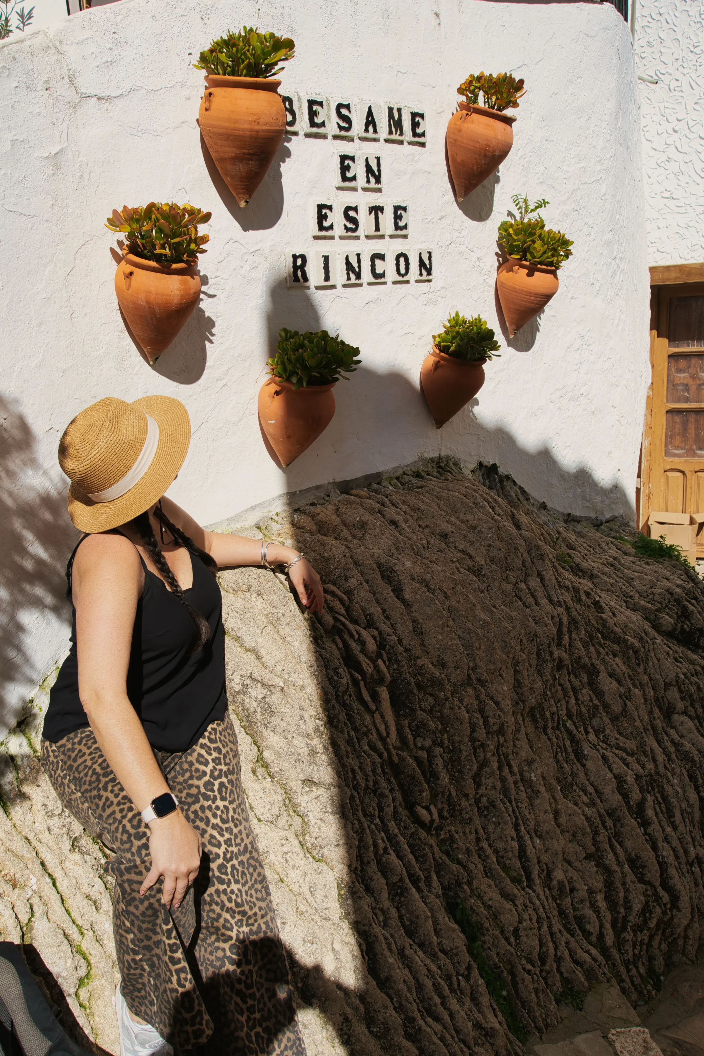 Heidi beside the "bésame en este rincón" tile on Calle Herrería in Setenil de las Bodegas
