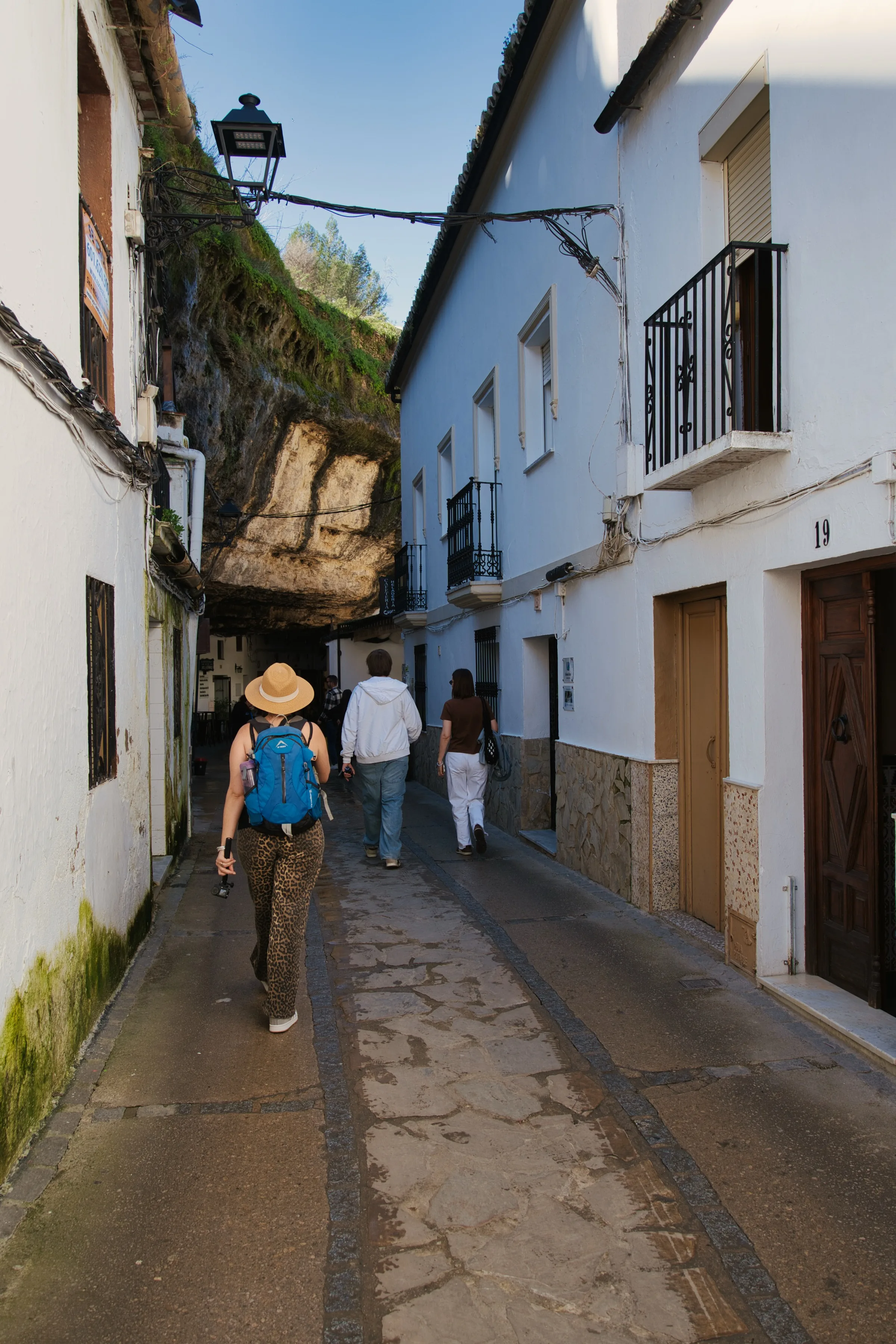 Heidi walking down a narrow street under the rock overhang in Setenil de las Bodegas