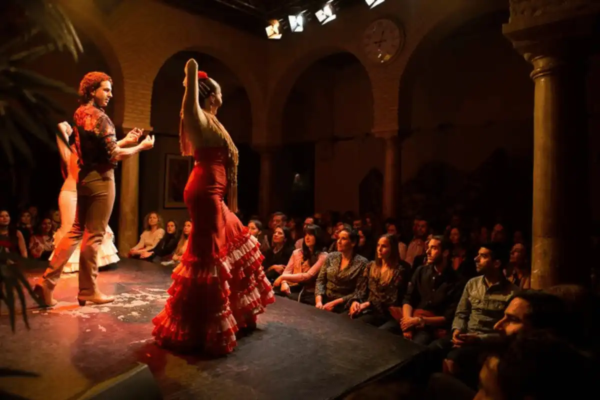 Flamenco performance on stage in Seville with dancers in colourful dresses