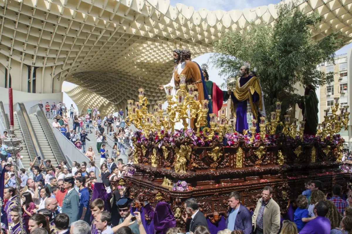 Semana Santa procession with floats moving through central Seville at night