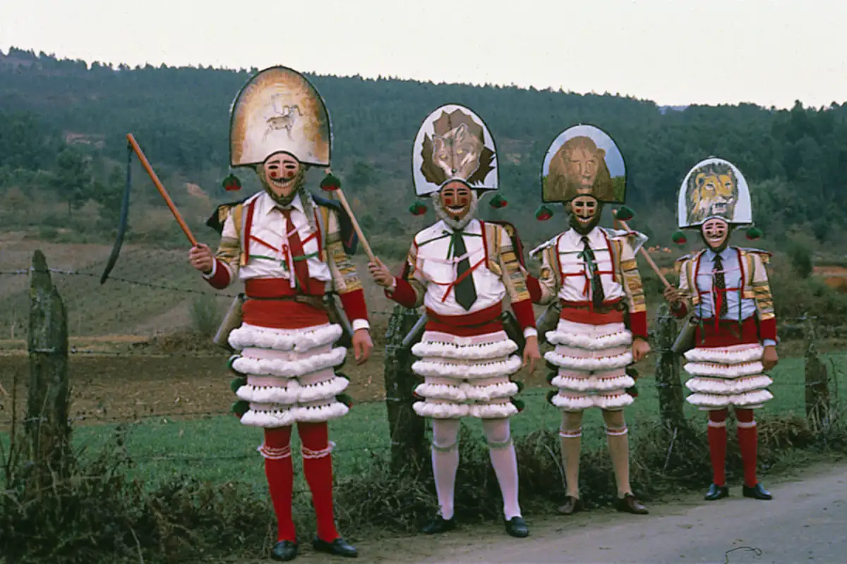 Masked carnival figures covered in mud during Entroido in Laza, Galicia