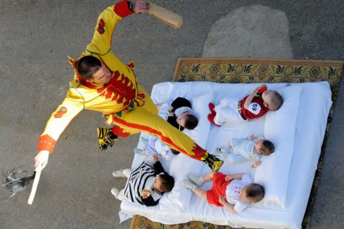 Man in devil costume leaping over babies during El Colacho festival in Castrillo de Murcia