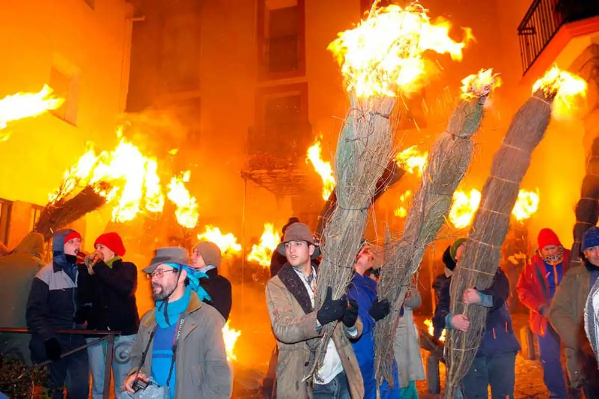Participants carrying burning broom torches through the streets at Los Escobazos, Jarandilla de la Vera