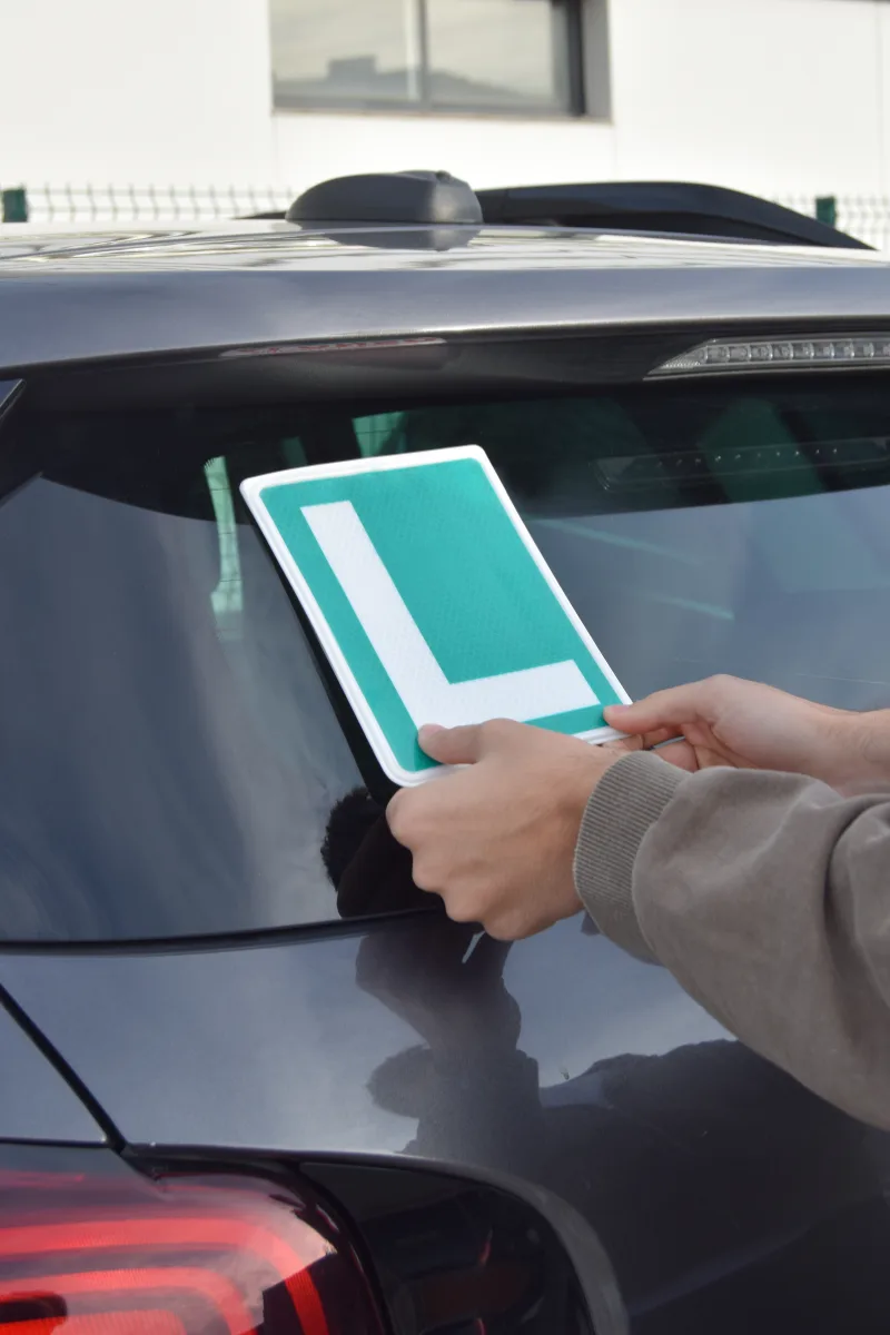 Attaching a green Spanish L-plate to a car's rear window