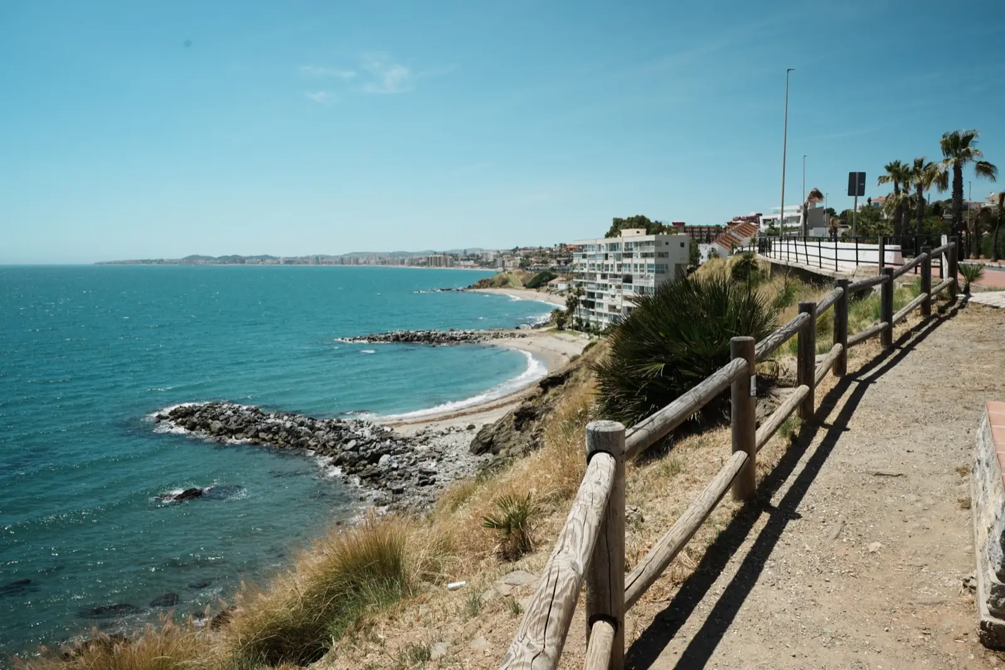 View along the Benalmadena coastline showing the beach and ocean from the seafront path