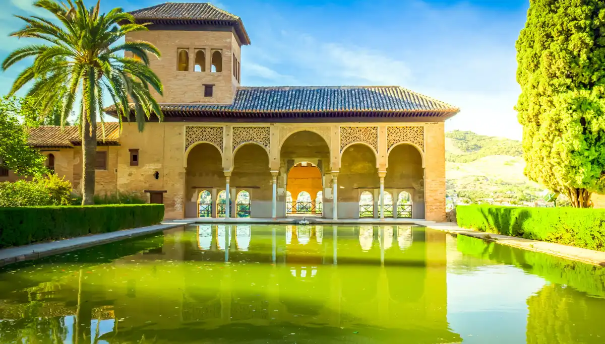 The Alhambra palace and gardens reflected in a still pool in Granada