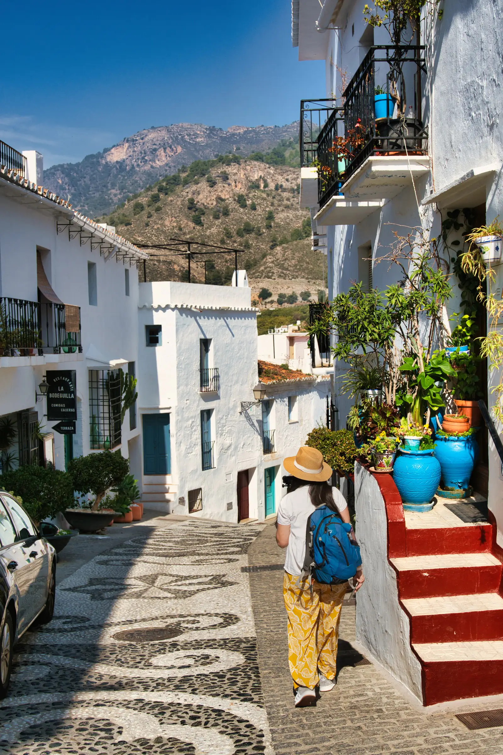 Woman walking down narrow street in Frigiliana.
