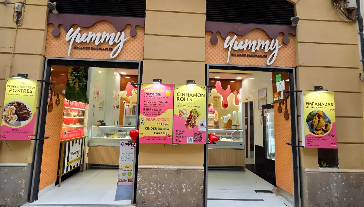 The pink and yellow storefront of YUMMY vegan ice cream shop in Malaga