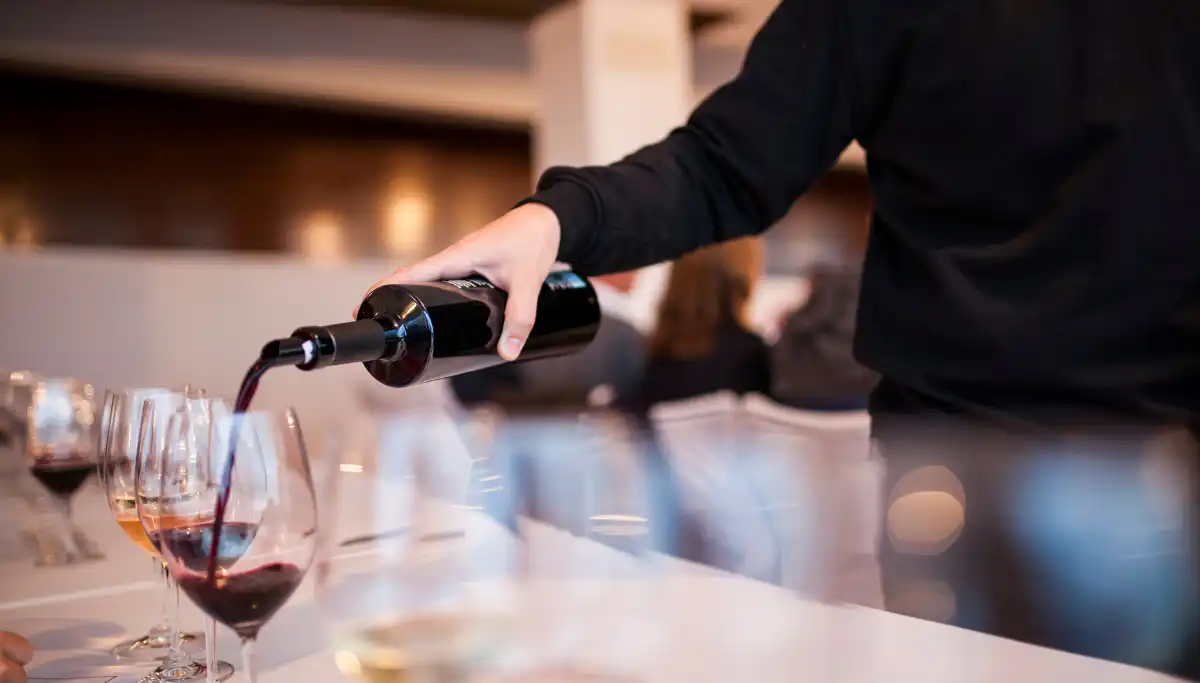 Red wine being poured at a bar counter during a wine tasting in Malaga