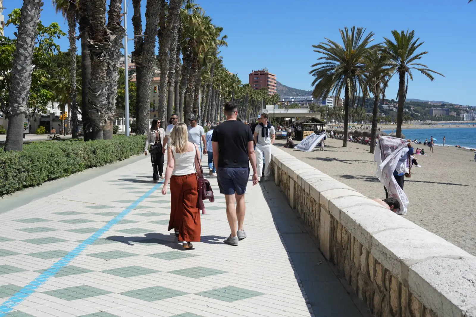 Couple walking along the Malagueta promenade in summer