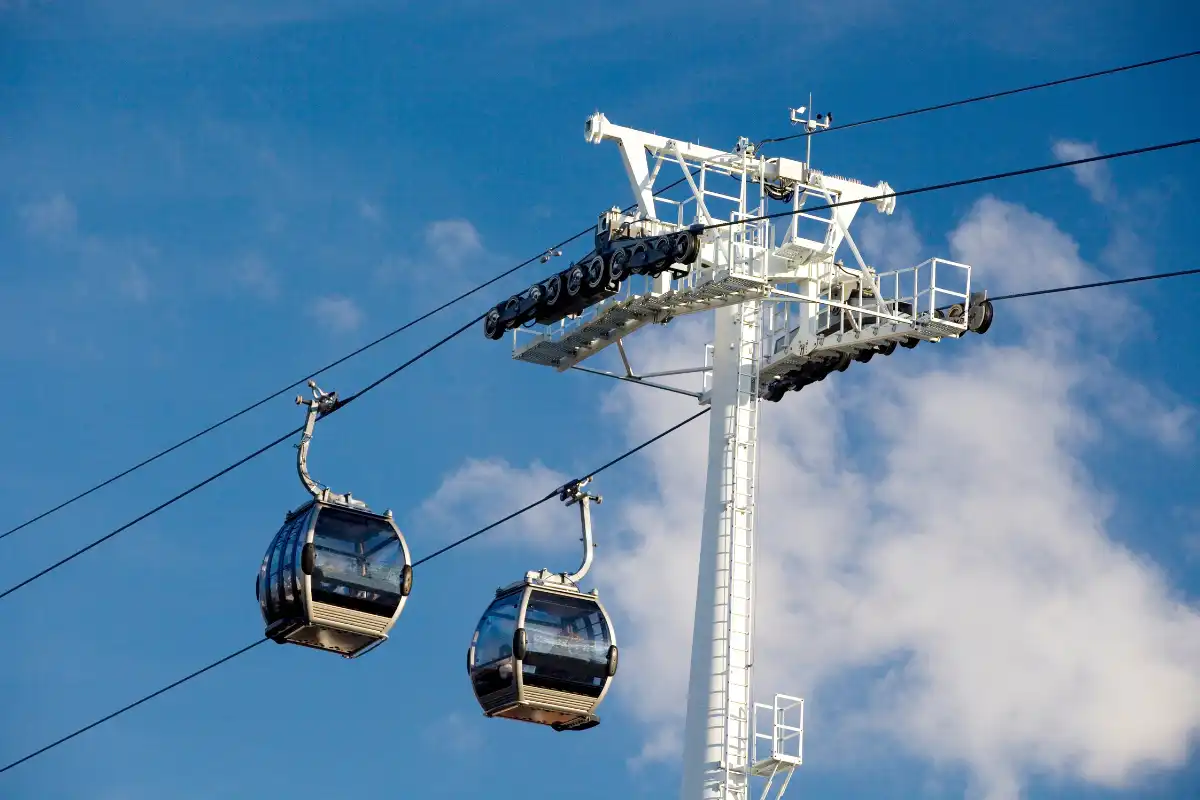 Two cable car cabins suspended above Benalmadena on a clear blue sky day