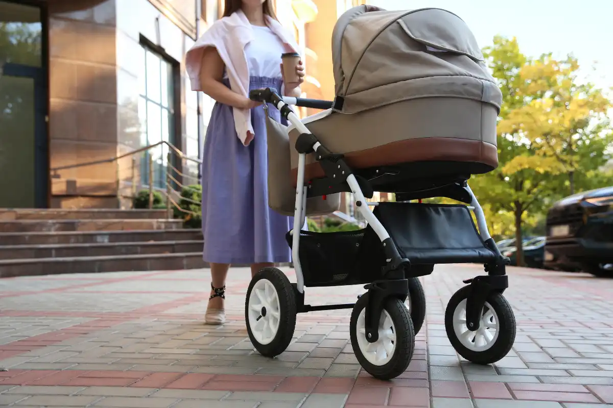 Mother pushing a pram along a paved street