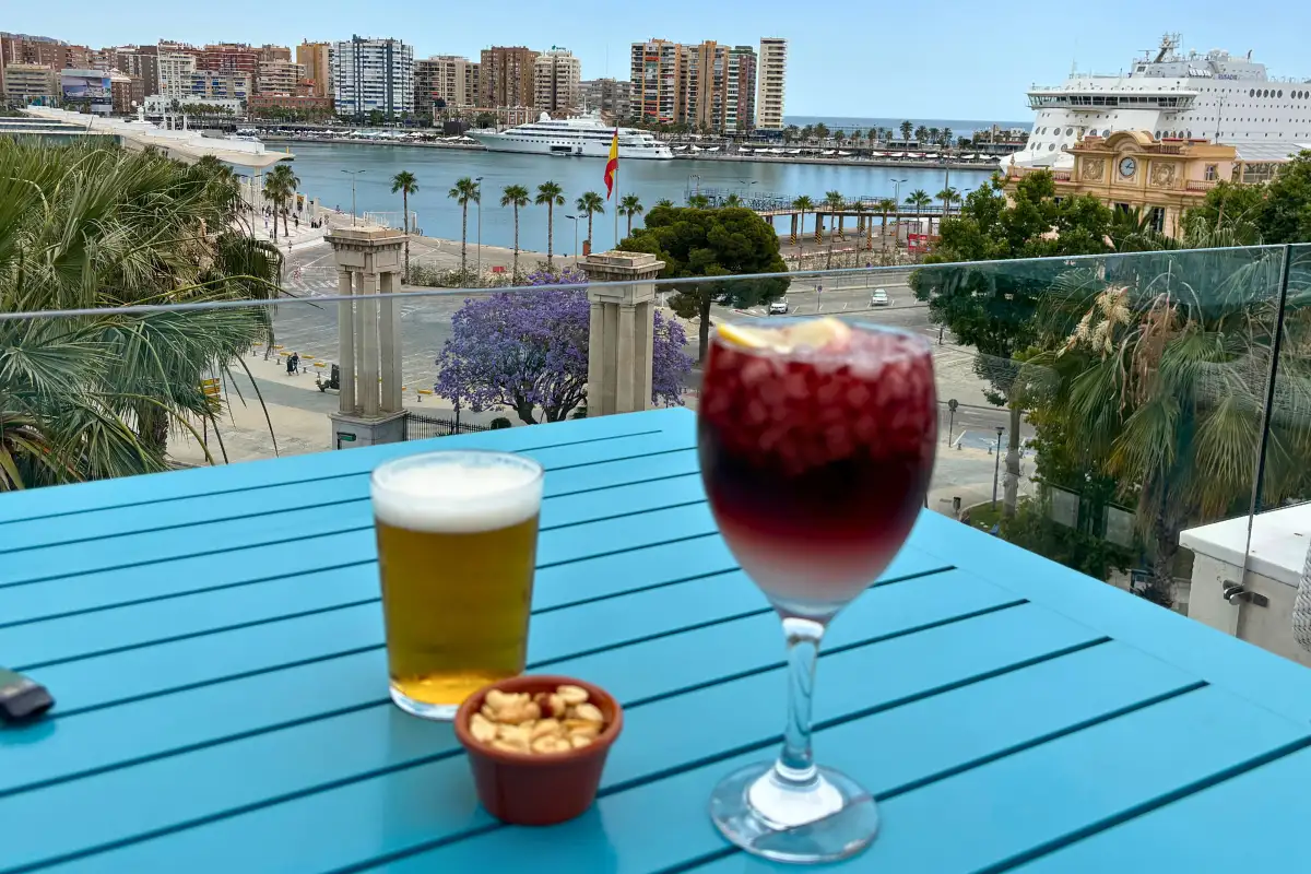 A cocktail on the La Terraza de Valeria rooftop in Malaga, with the walls of Gibralfaro Castle rising above the old town rooftops behind