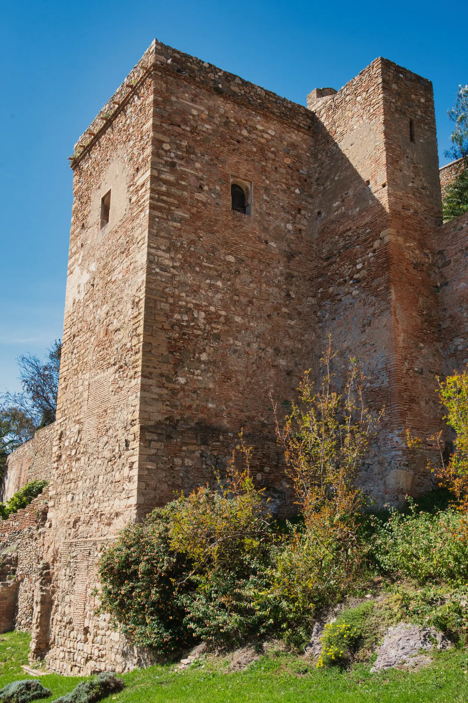 The Alcazaba fortress turret with stone walls and blue sky