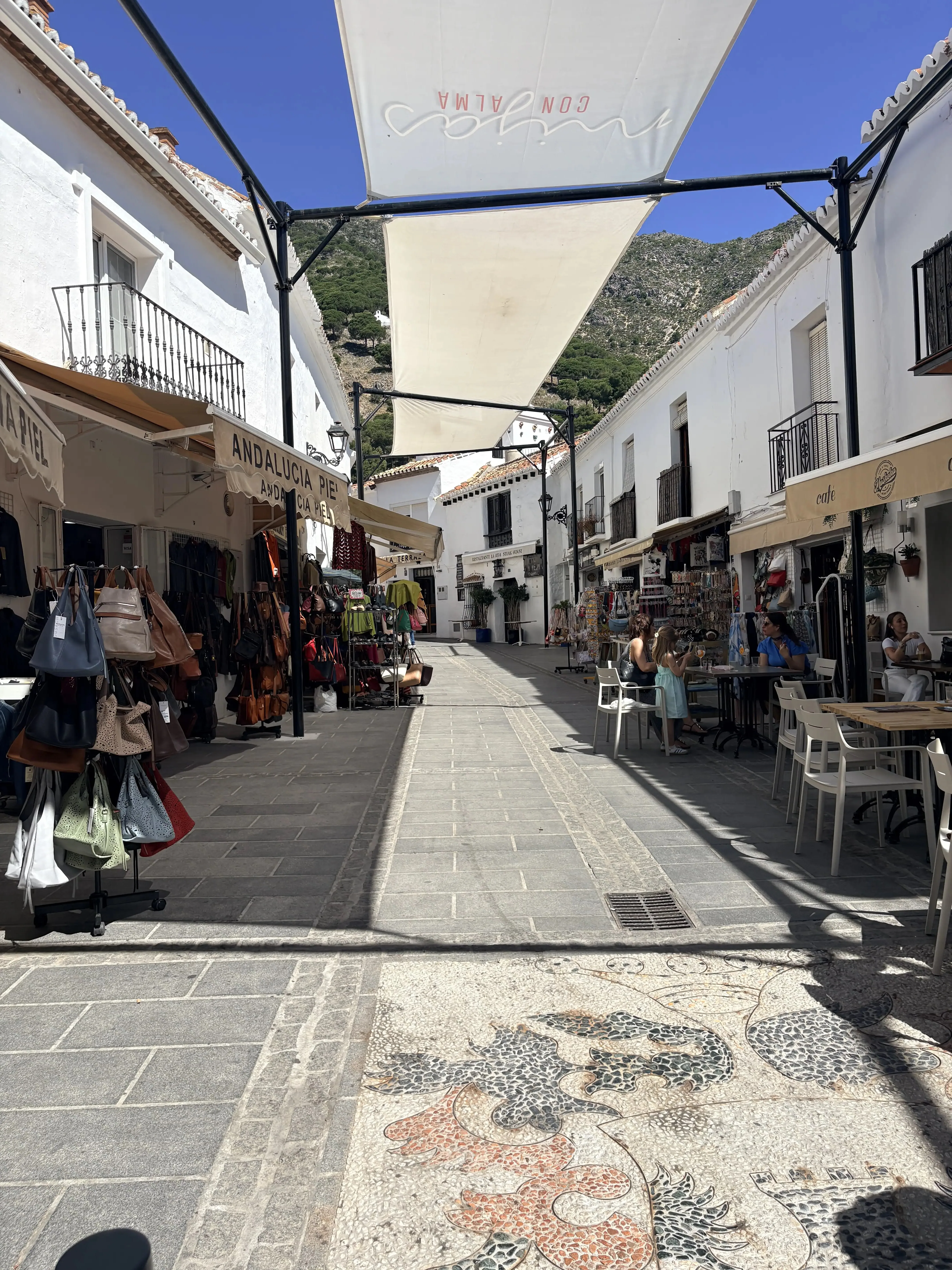 Covered market street in Mijas Pueblo with Andalucia Con Alma awning and craft stalls