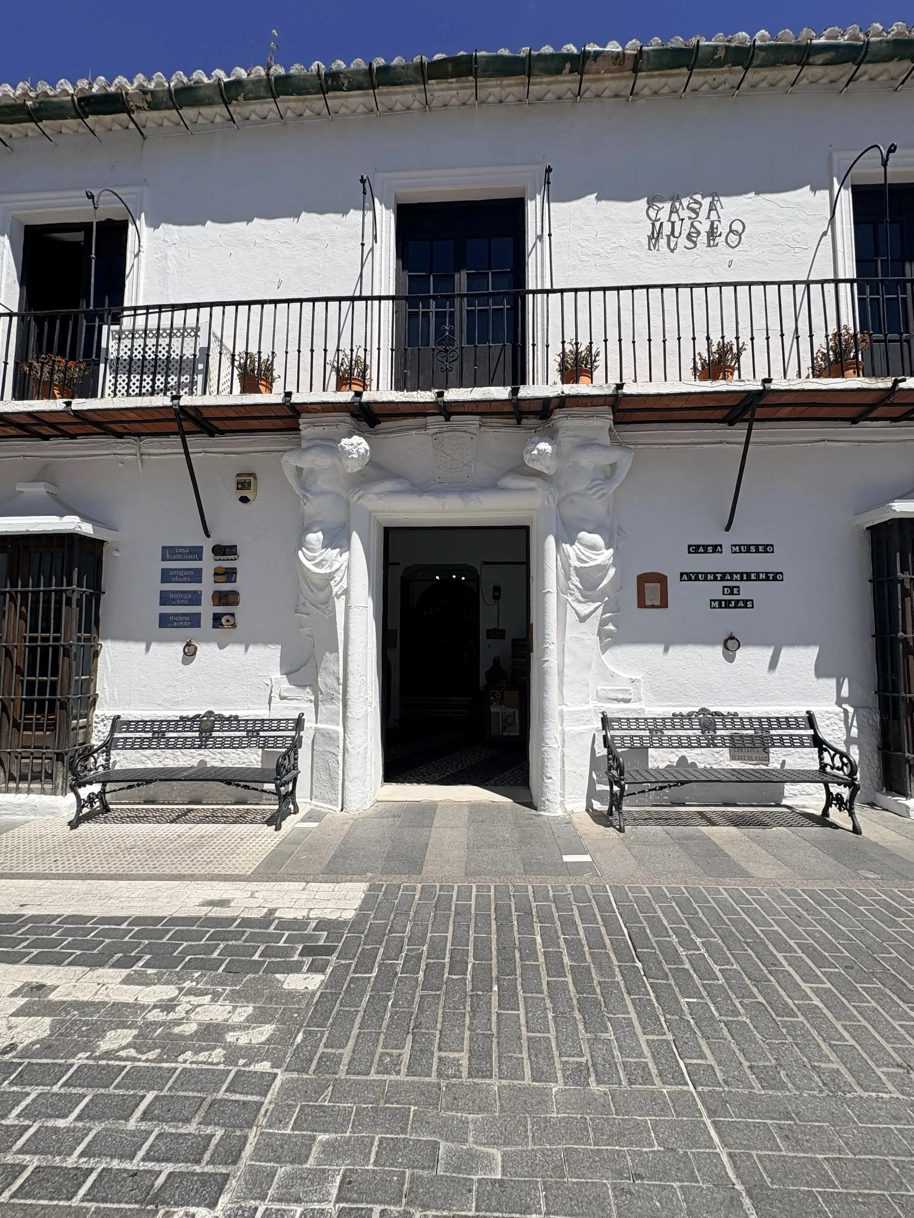 White facade of the Mijas museum building with statues and ornate balconies