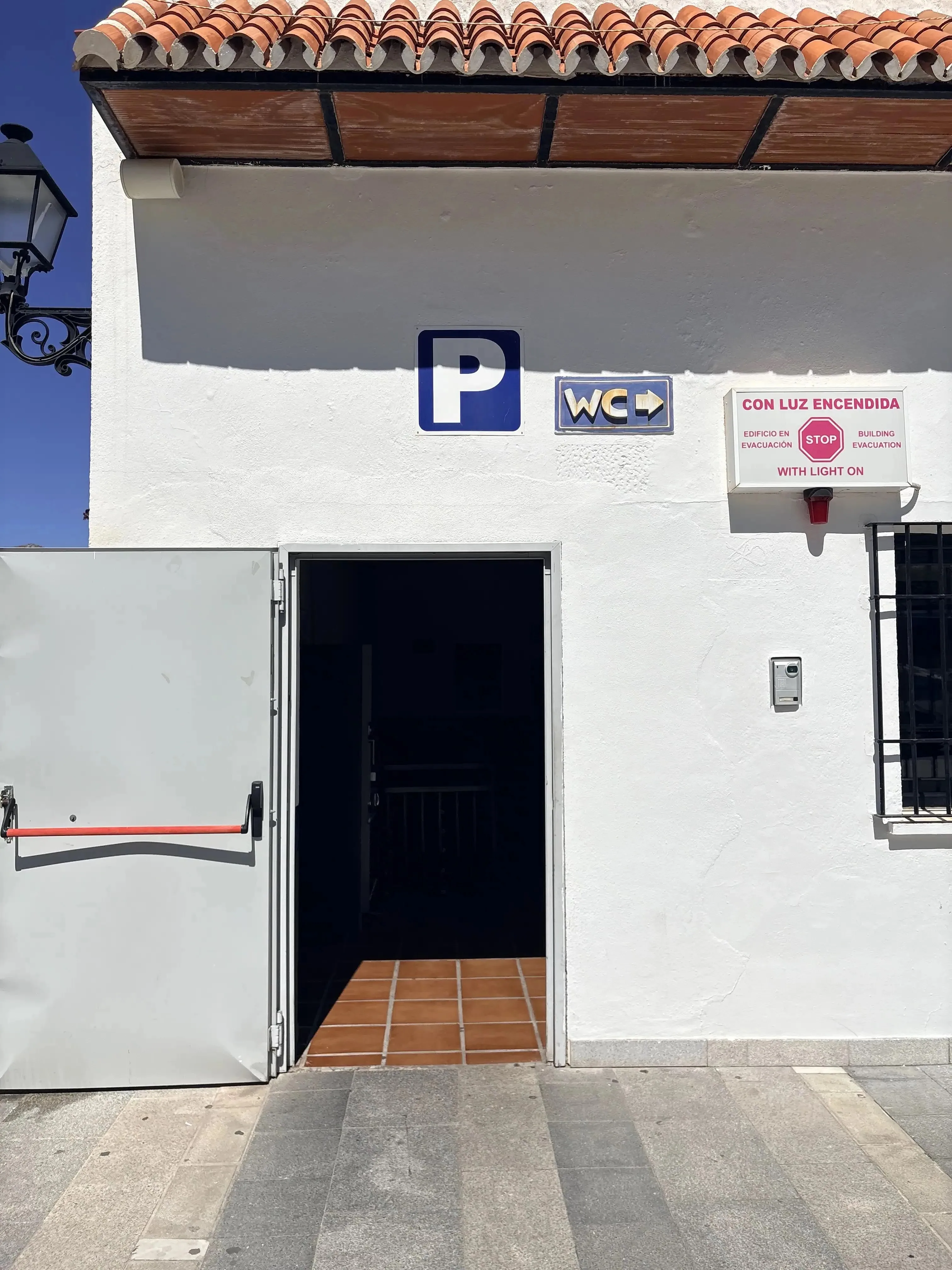 The entrance to the Mijas Pueblo car park with a blue P sign and WC arrow above the door