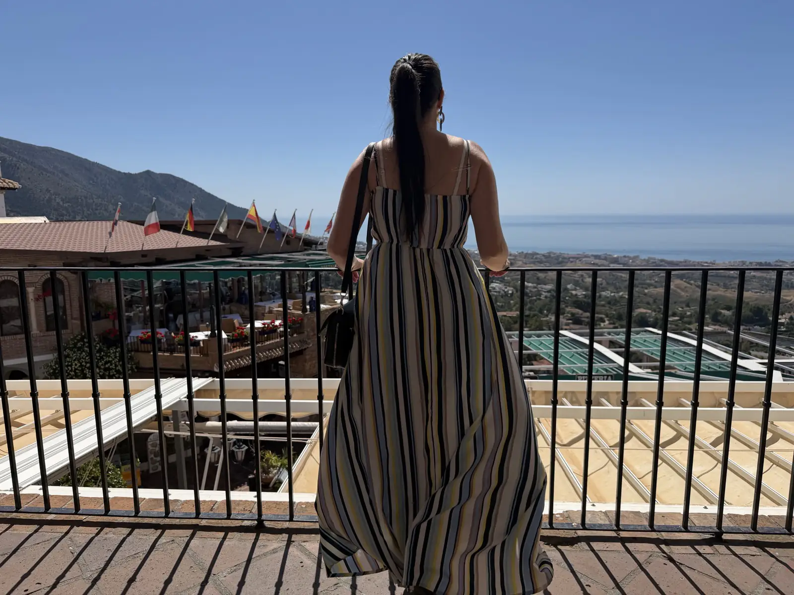 Heidi looking over the restaurant terraces with coastal views in Mijas Pueblo