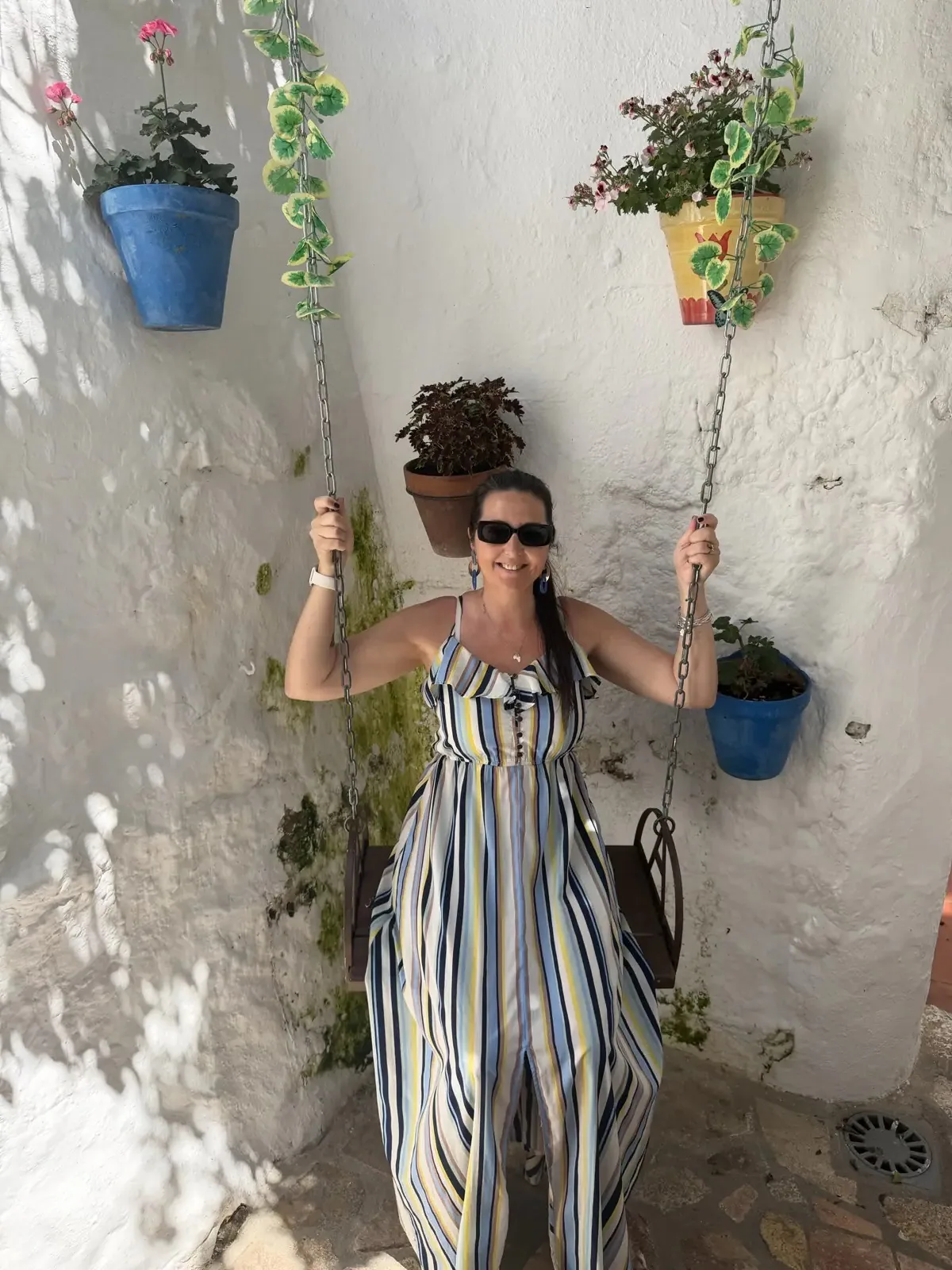 Heidi sitting on the swing in the outdoor courtyard of The Secret Garden in Mijas Pueblo