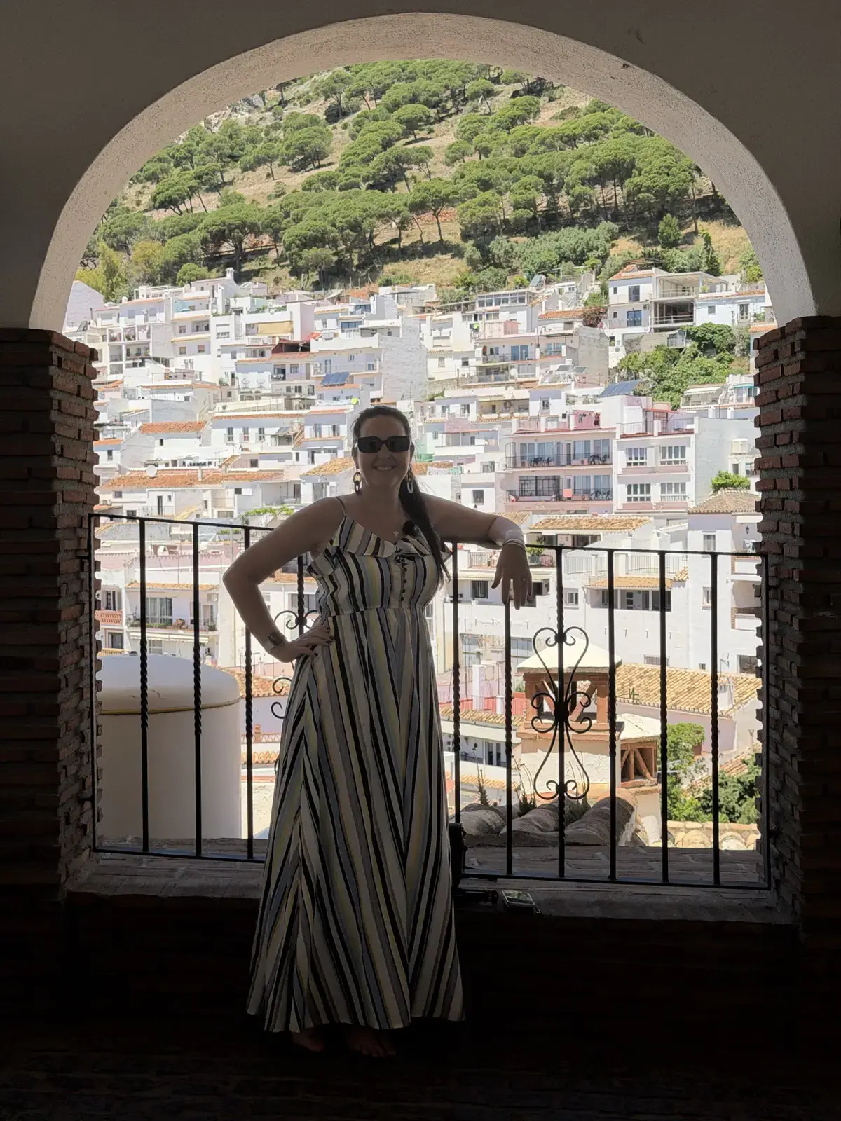 Selfie through an arch in Mijas Pueblo with the white village behind