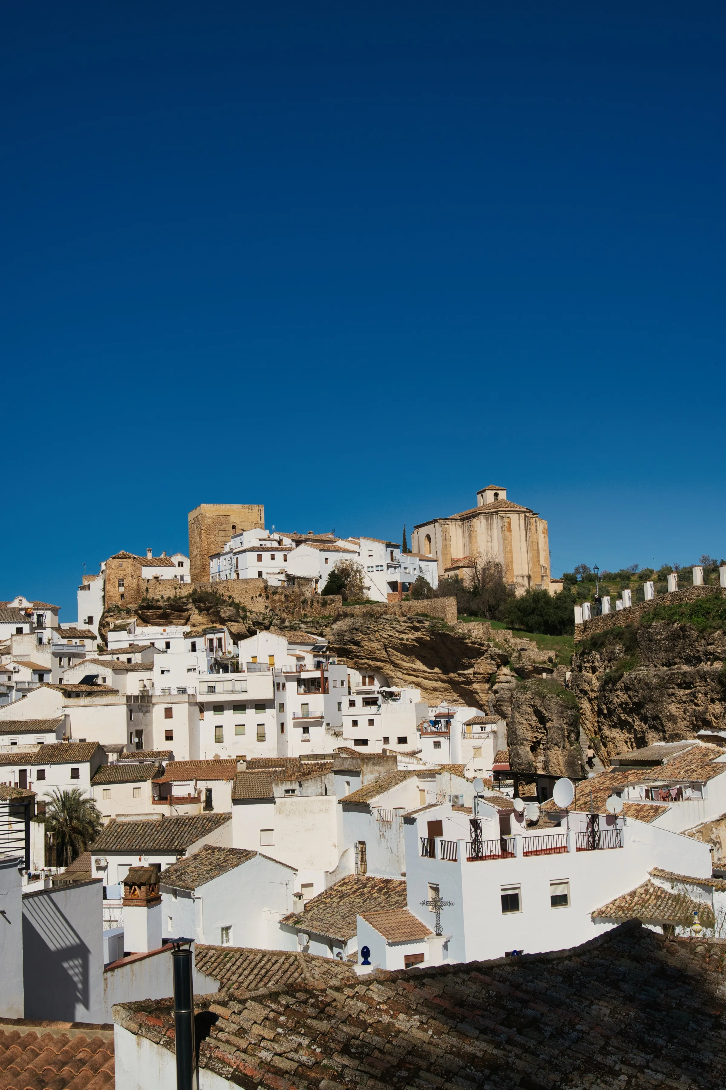 An old town with a tower on a hill and blue sky background.