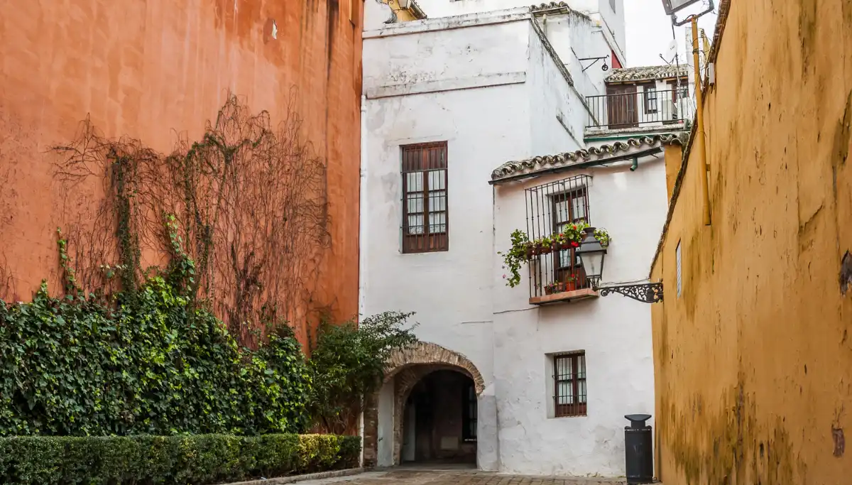 Narrow street in Barrio Santa Cruz with orange, white, and yellow walls