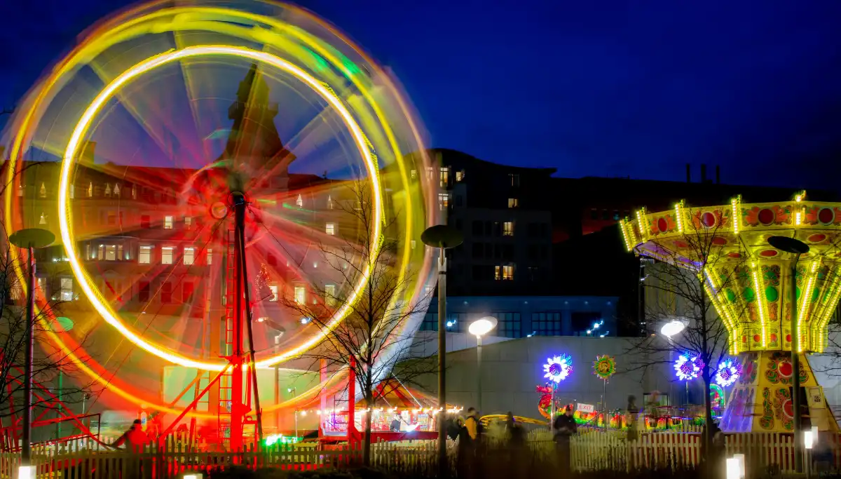 Fairground rides lit up at night at Calle del Infierno, Feria de Abril Seville