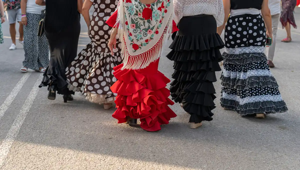 Women in flamenco dresses walking through Feria de Abril Seville