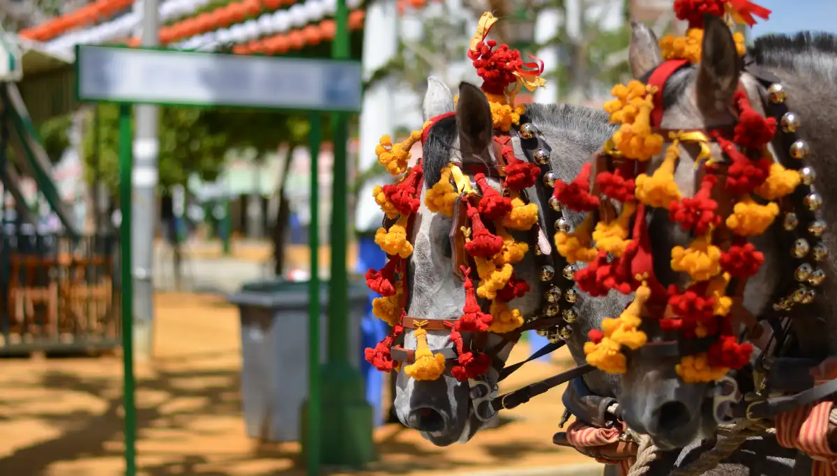 Decorated horses with red pompoms at Feria de Abril Seville