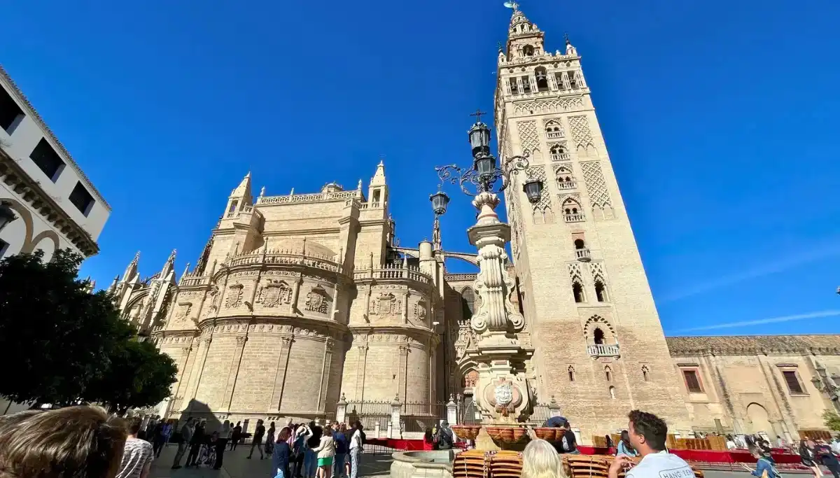 The Giralda tower and Seville Cathedral exterior against a blue sky