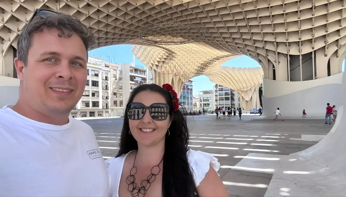 Couple standing beneath the wooden structure of Las Setas in Seville
